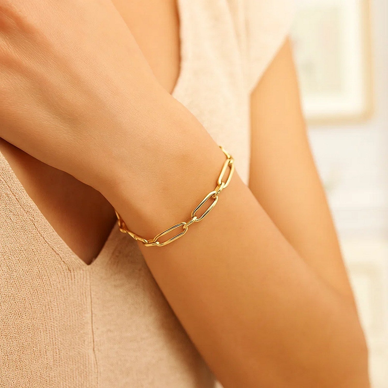 14k yellow gold Bombay paperclip chain bracelet on a person's arm.