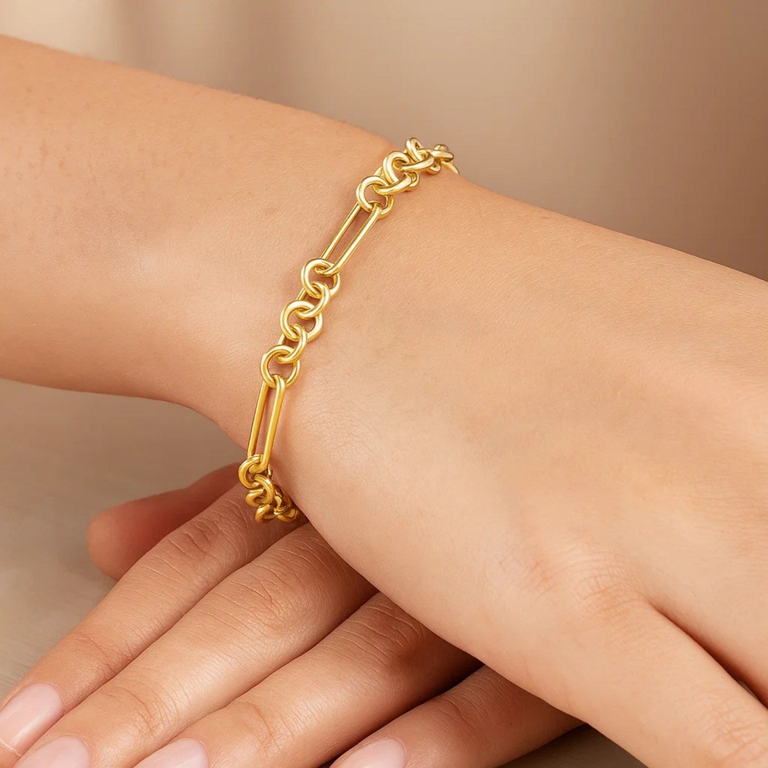 14K yellow gold five and one paperclip link chain bracelet on a person's wrist.