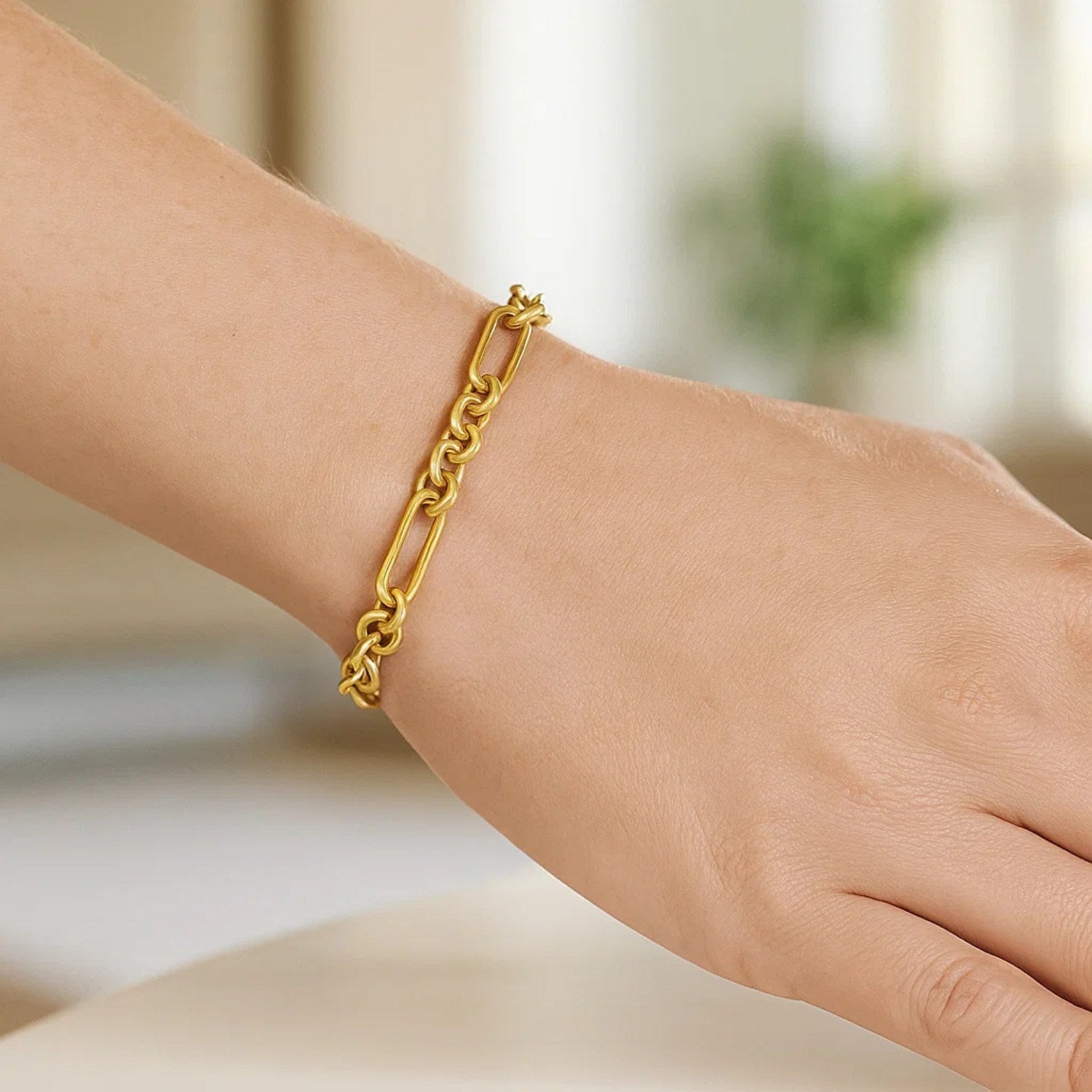 14K yellow gold five-and-one paperclip link chain bracelet on a wrist.