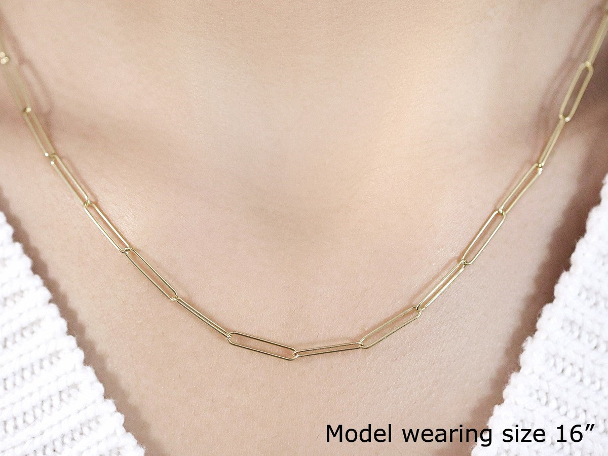 A 14k yellow gold paperclip chain with 2.7mm links is worn around a model's neck.