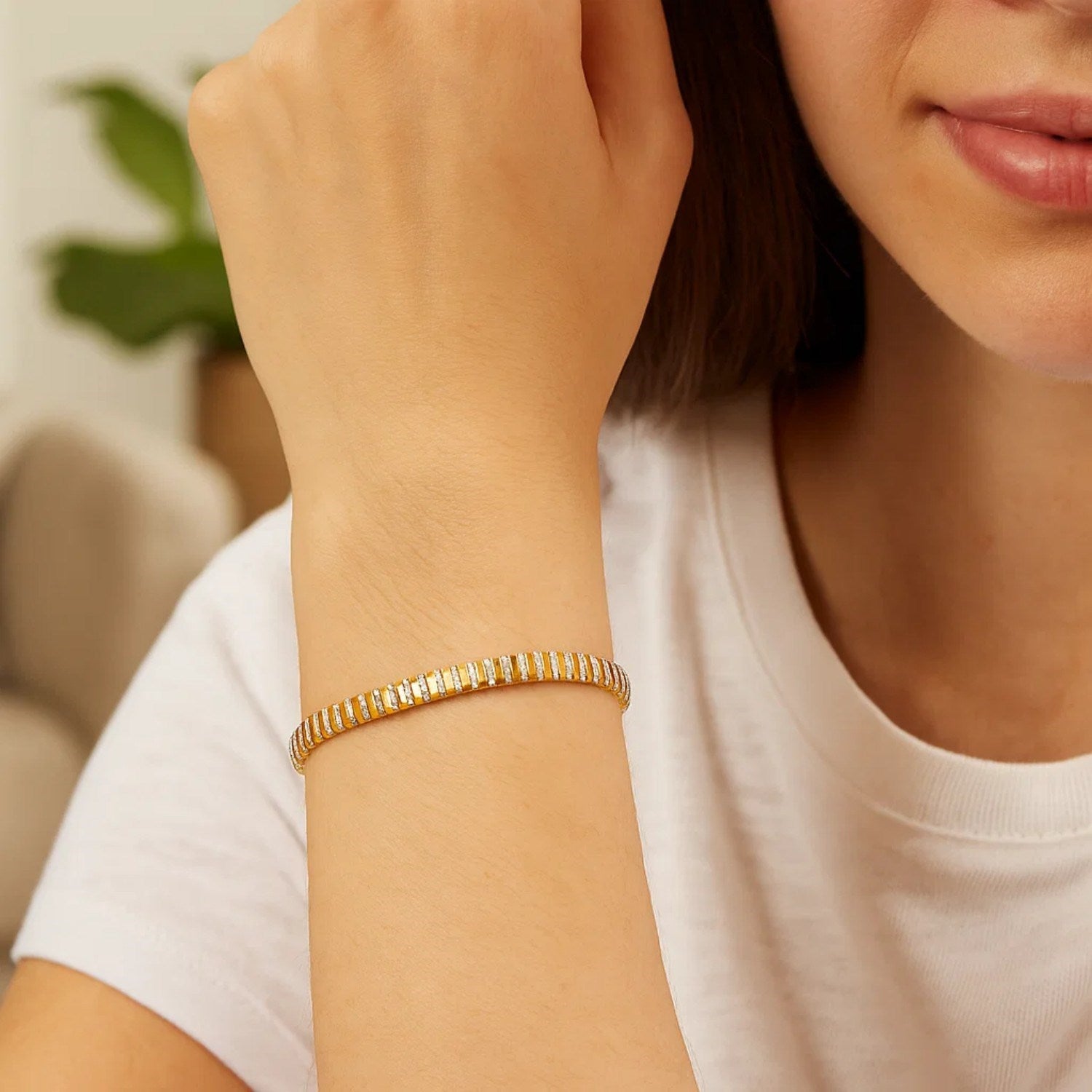 14K two-tone gold mini diamante bracelet on a woman's wrist.
