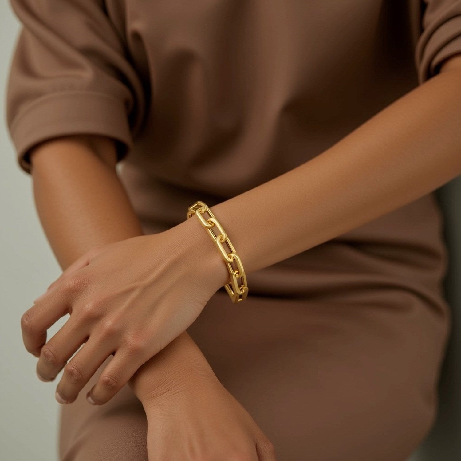 14k yellow gold extra wide paperclip chain bracelet on a person's wrist.