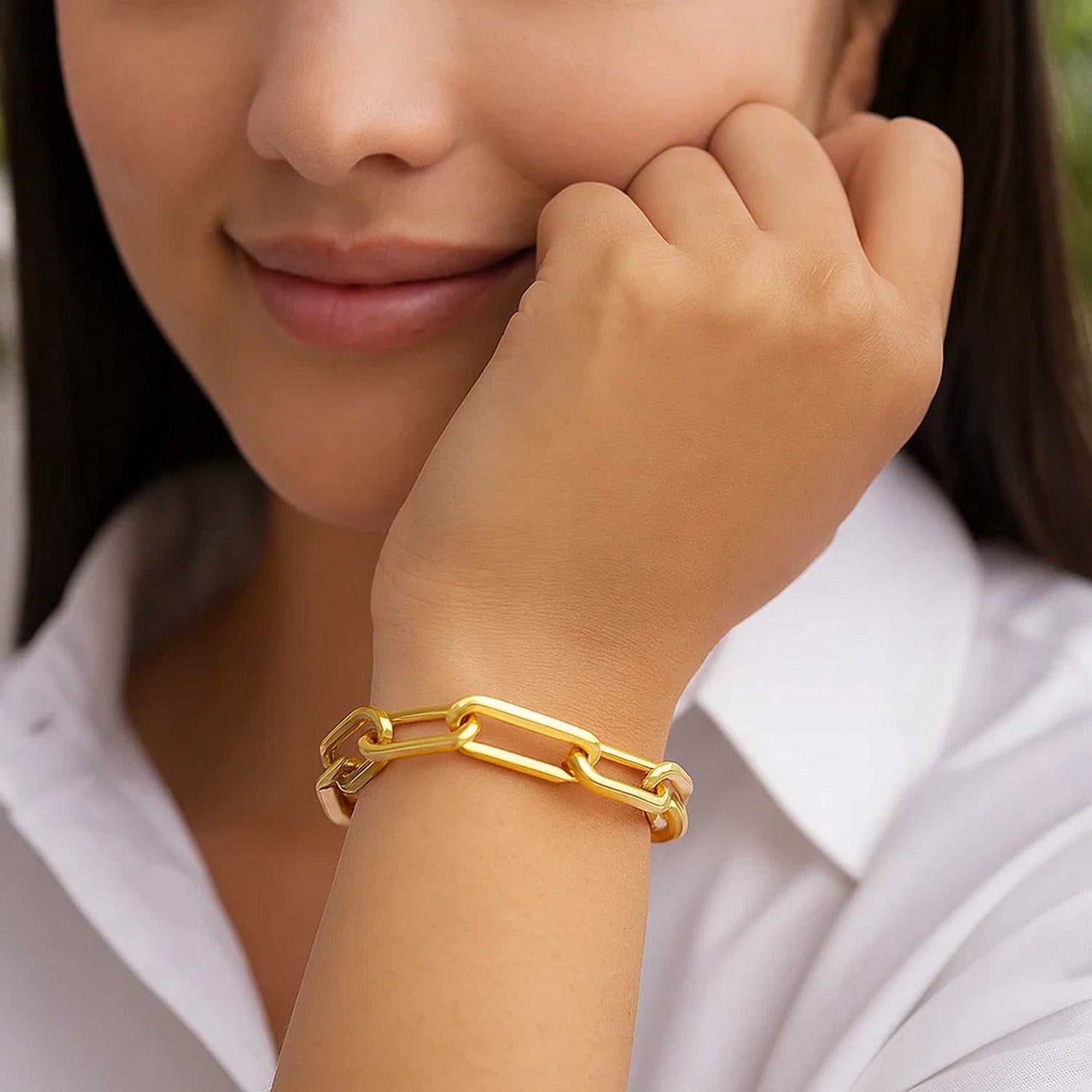 14k yellow gold extra wide paperclip chain bracelet on a woman's wrist.