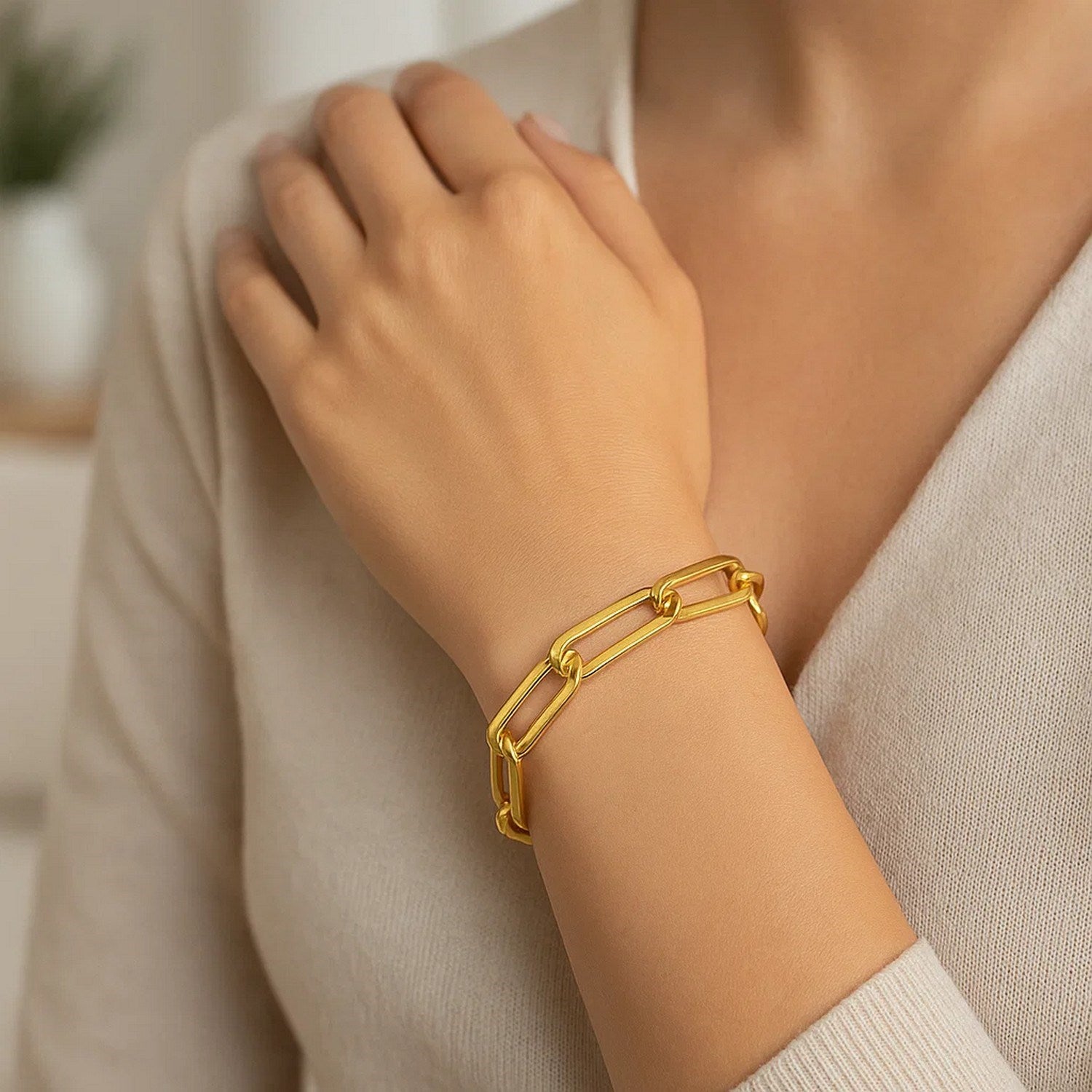 14k yellow gold 8-inch extra wide paperclip chain bracelet on a woman's wrist.
