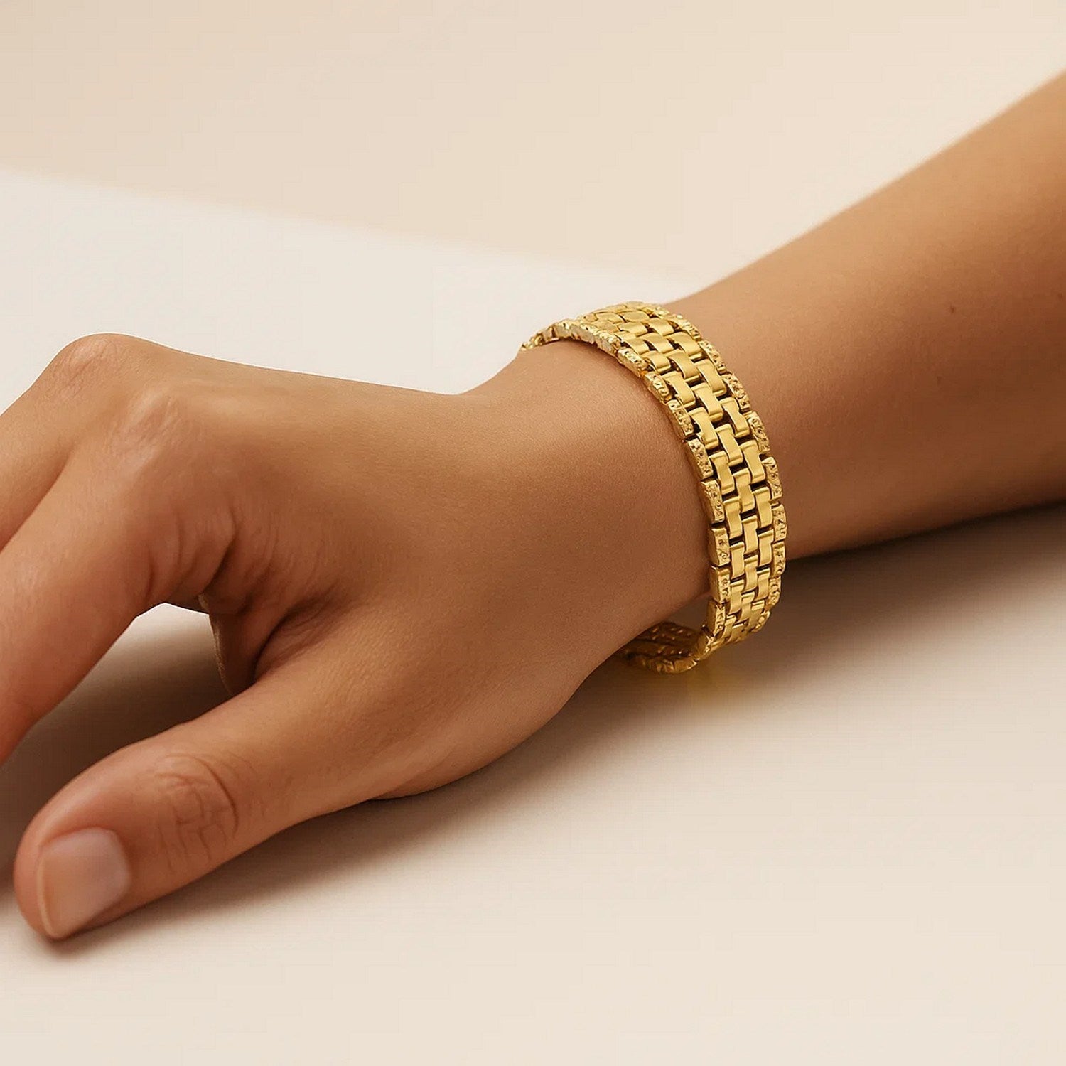 Panther link medium bracelet in 14K yellow gold on a person's wrist.