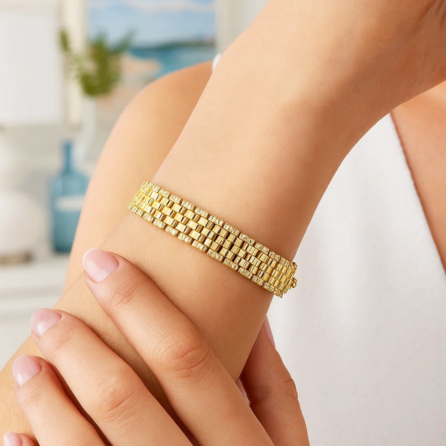 Panther link medium bracelet in 14K yellow gold with diamond-cut accents on a woman's arm.