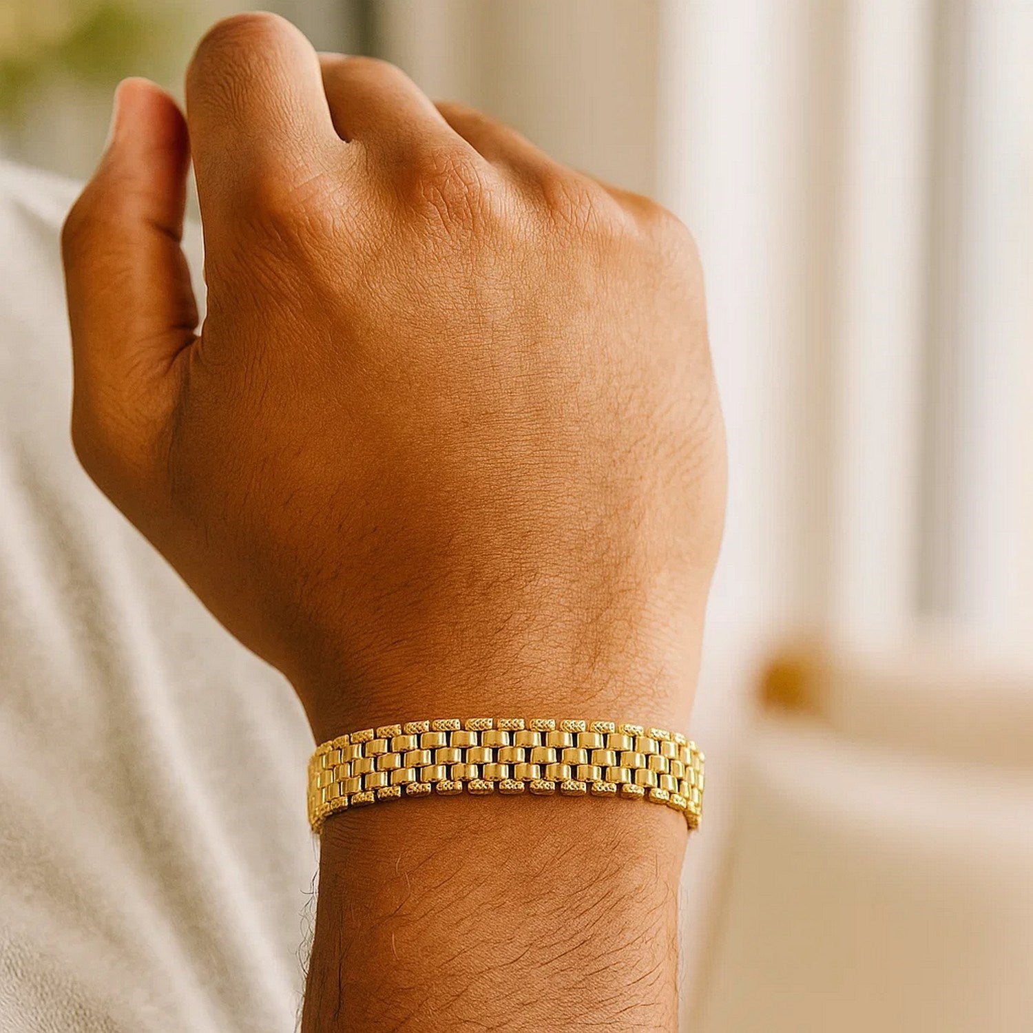 A man's arm wears a 14K yellow gold panther link bracelet.