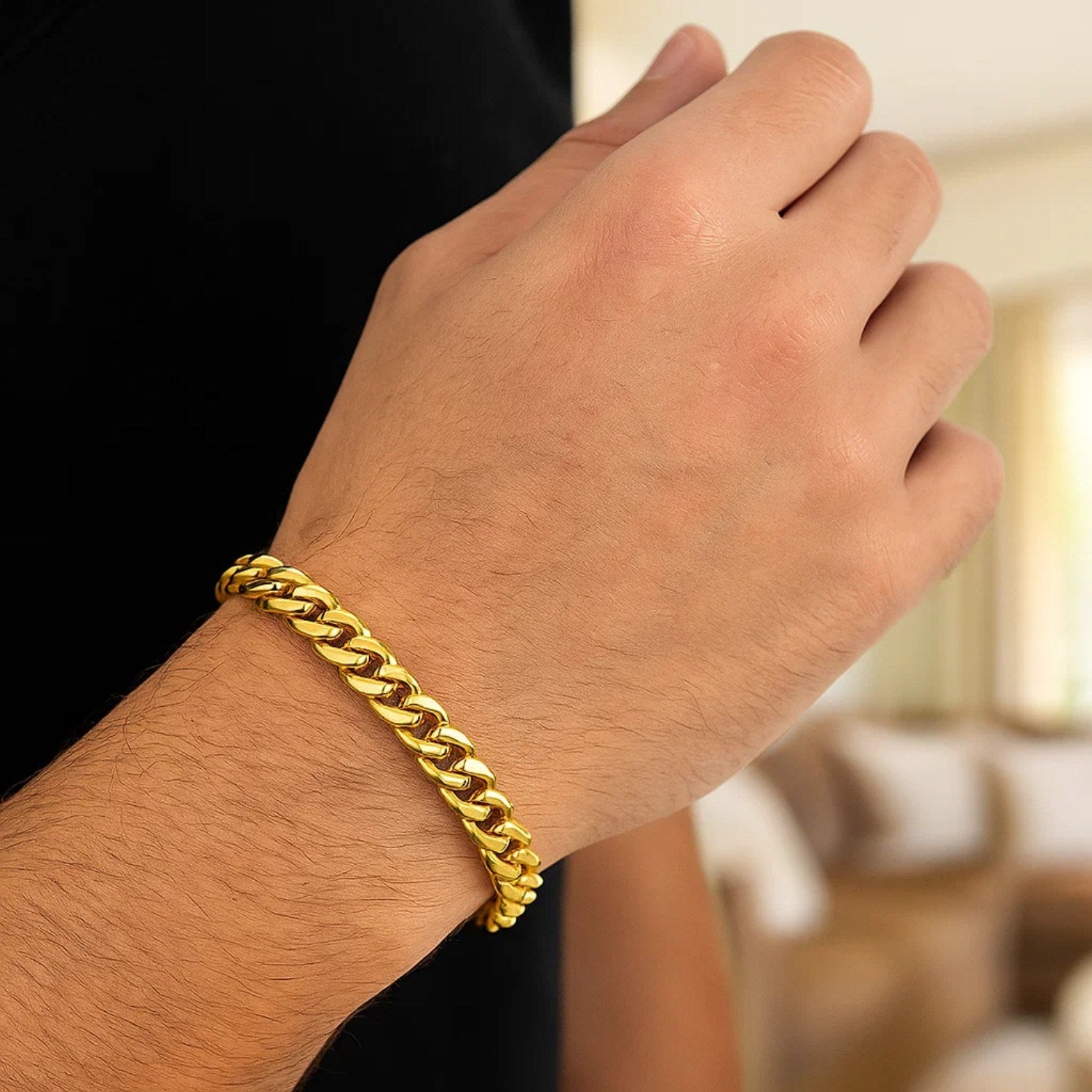 A 14k yellow gold classic Miami Cuban solid bracelet on a person's wrist.