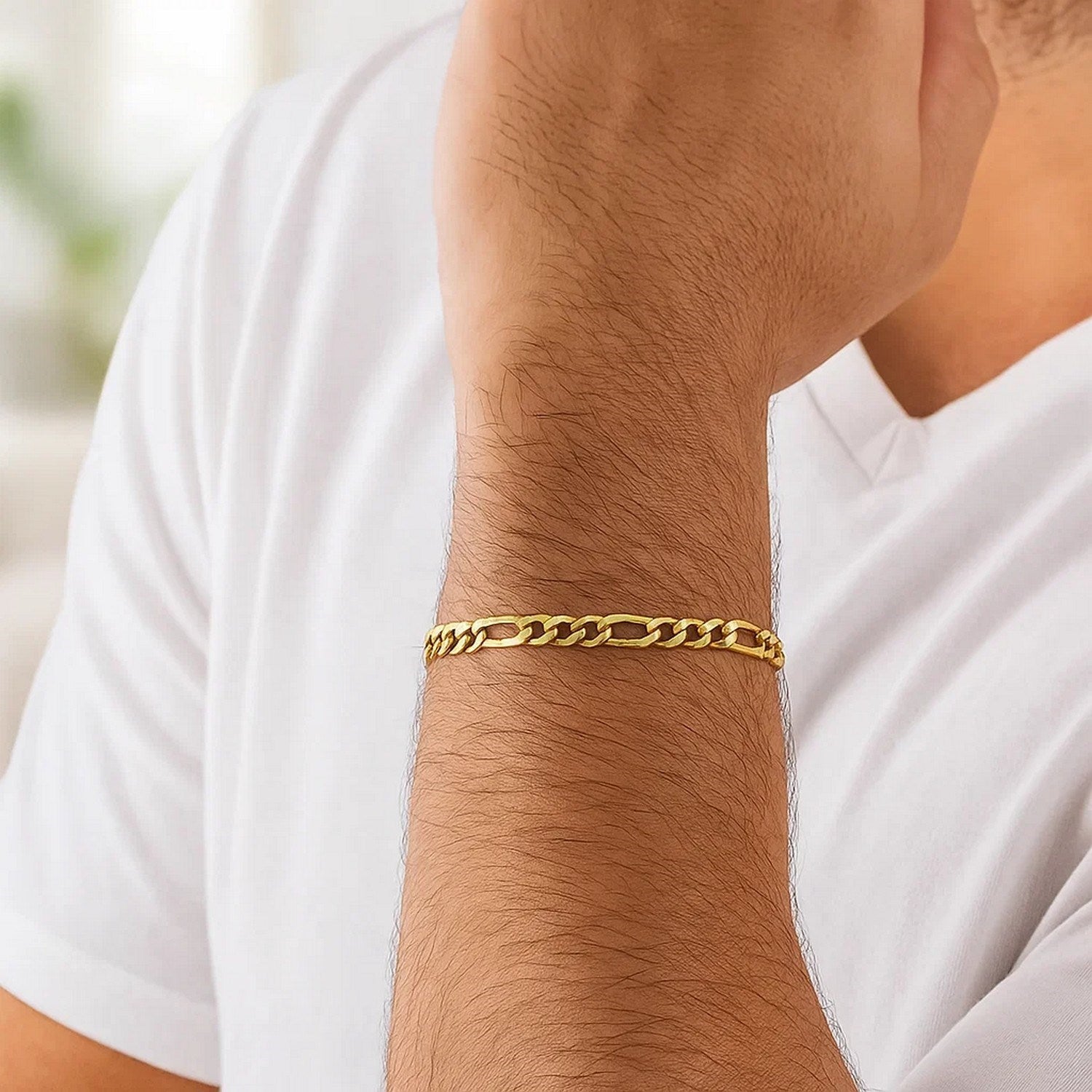 10k yellow gold Figaro link bracelet on a person's arm.