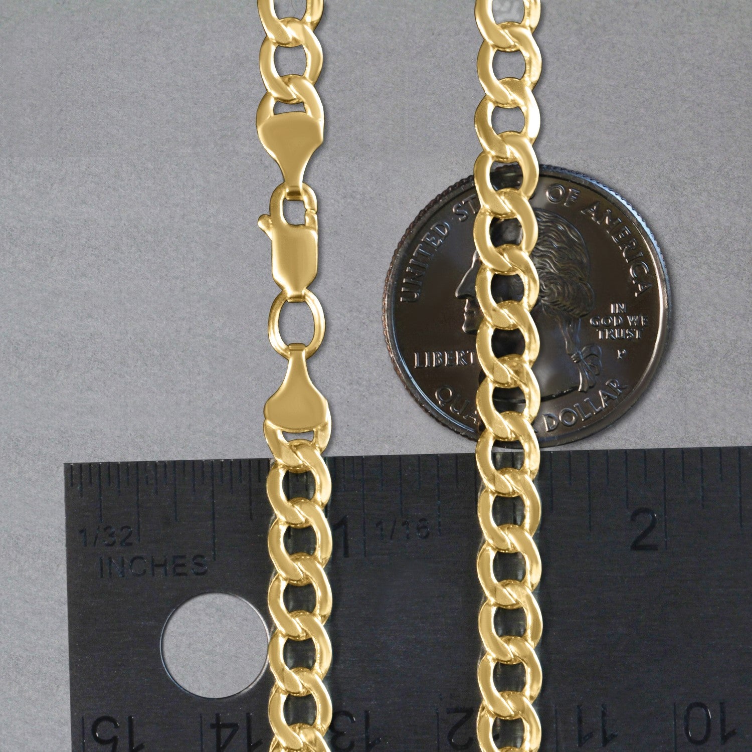 A 10k yellow gold curb chain with a lobster clasp, shown next to a ruler and a quarter.