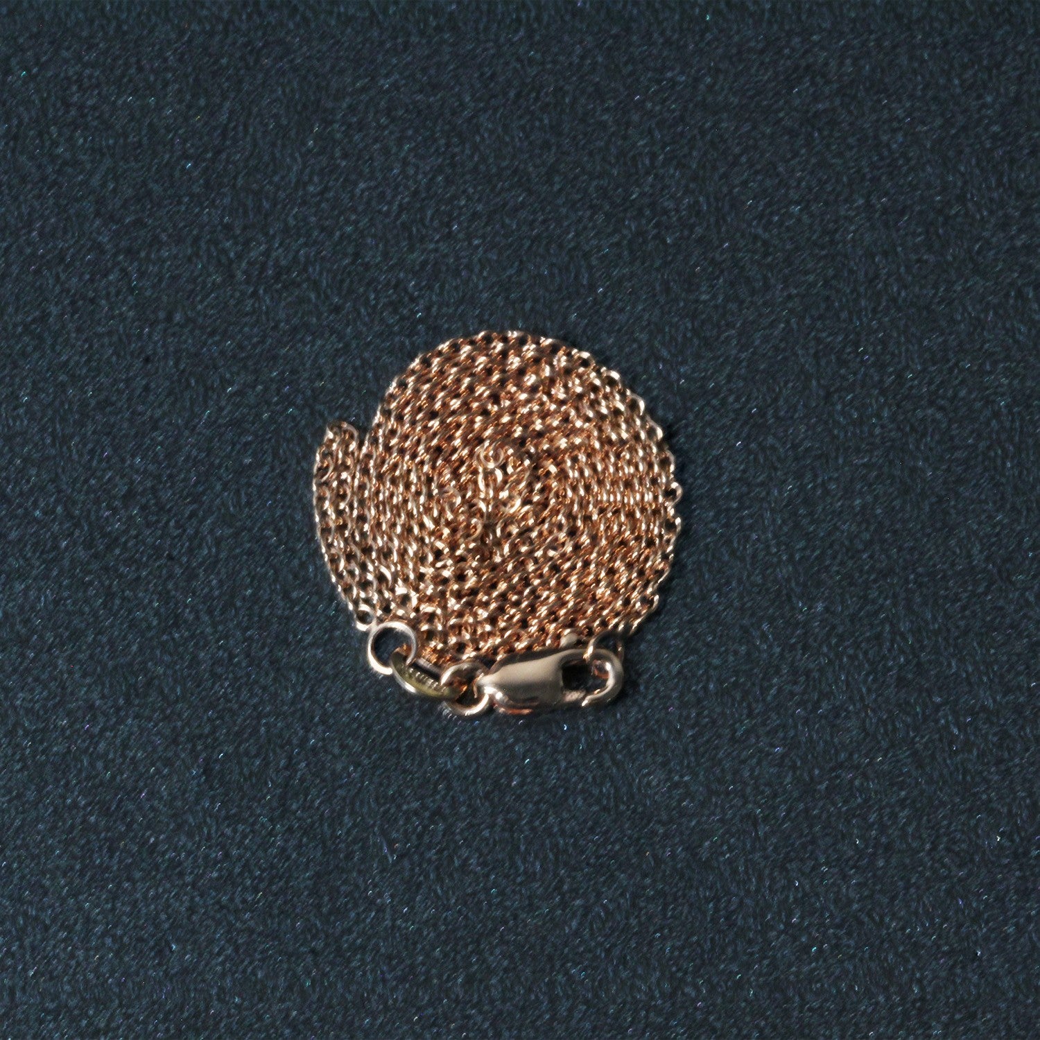 A coiled 14k rose gold round cable link chain with a lobster clasp.