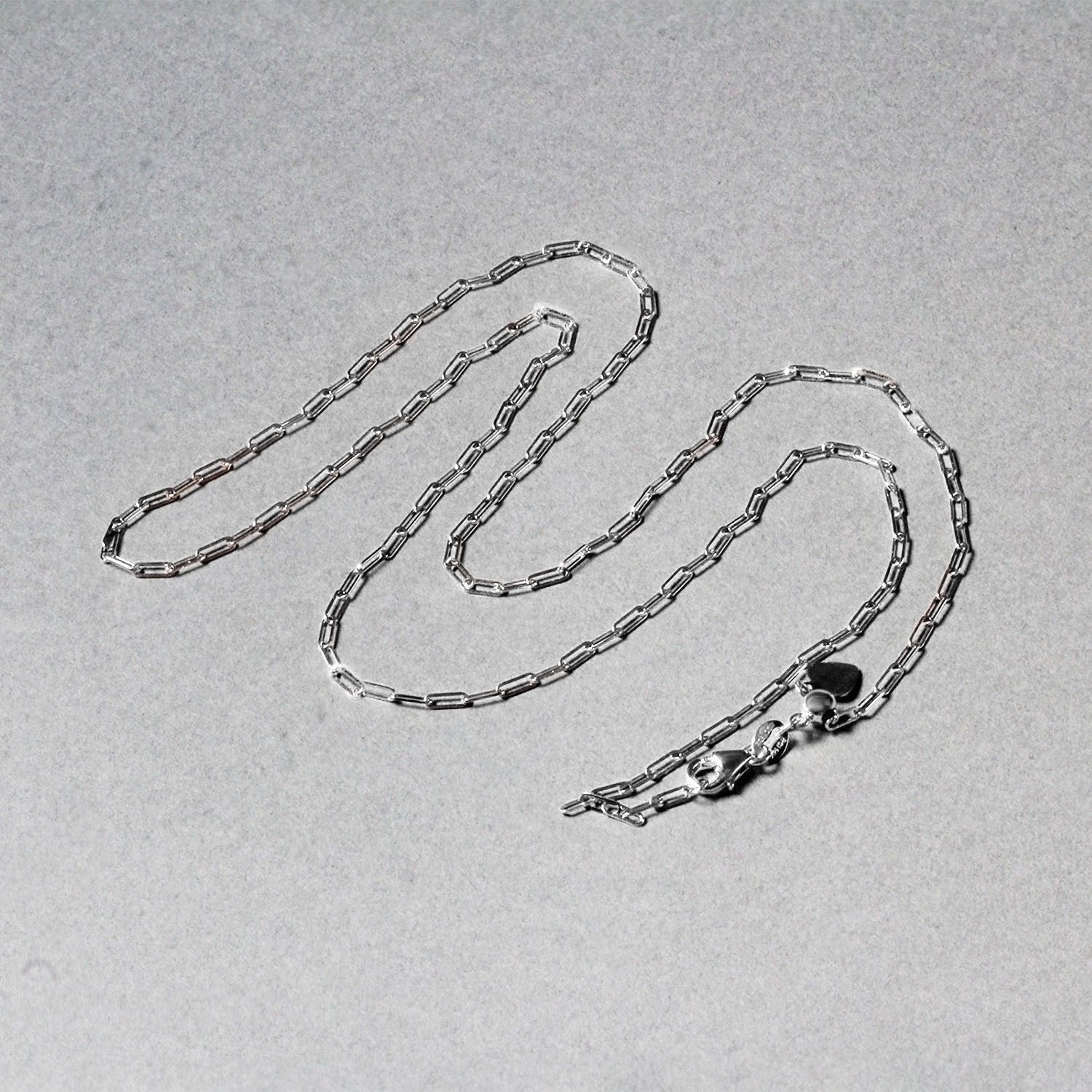 14k white gold adjustable paperclip chain with a heart dangle accent.