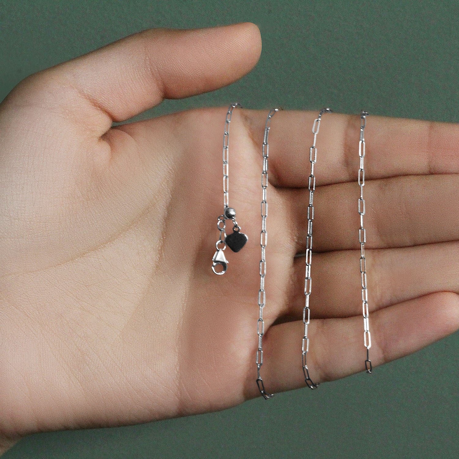 14k white gold adjustable paperclip chain with a heart dangle accent.