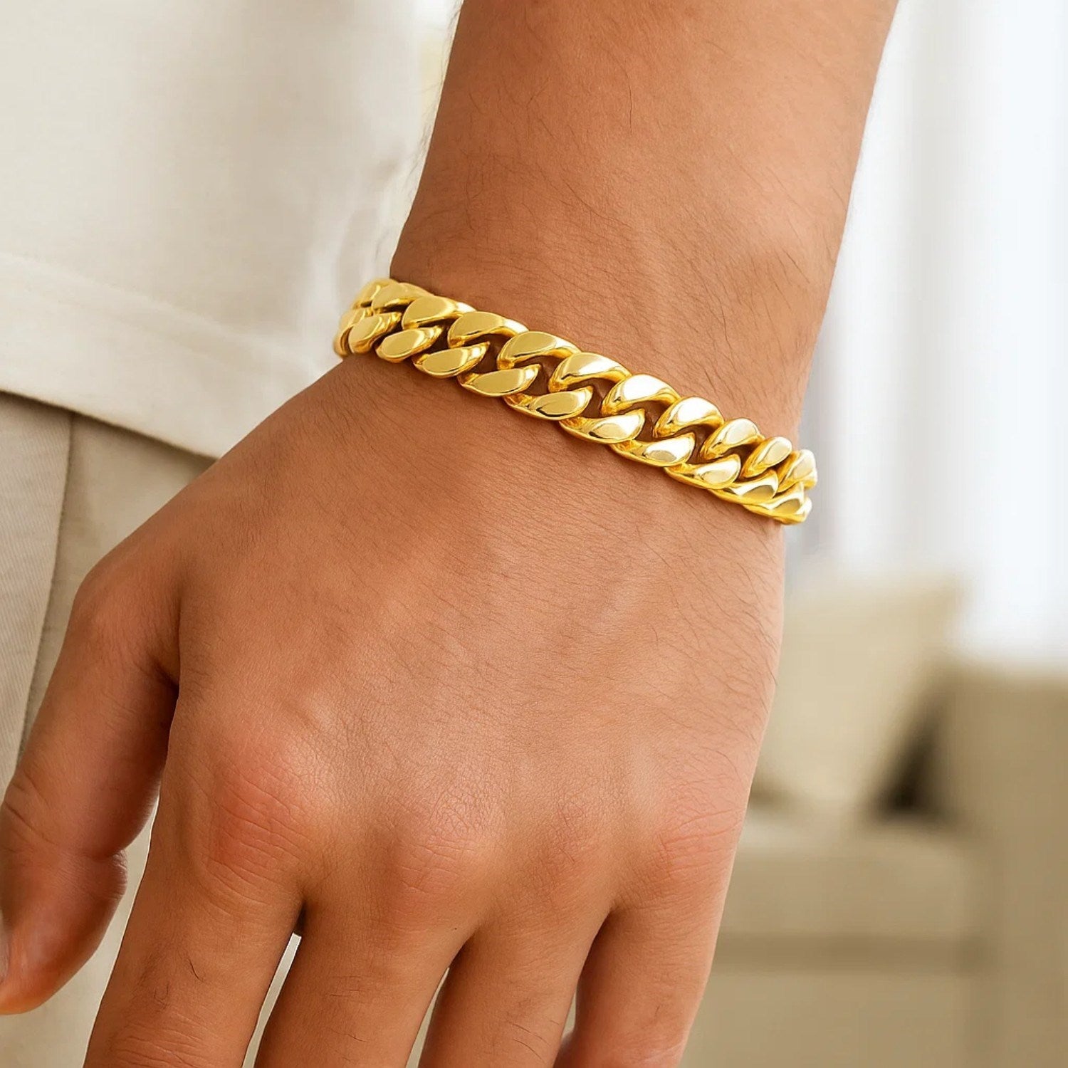 14k yellow gold classic Miami Cuban solid bracelet on a person's wrist.