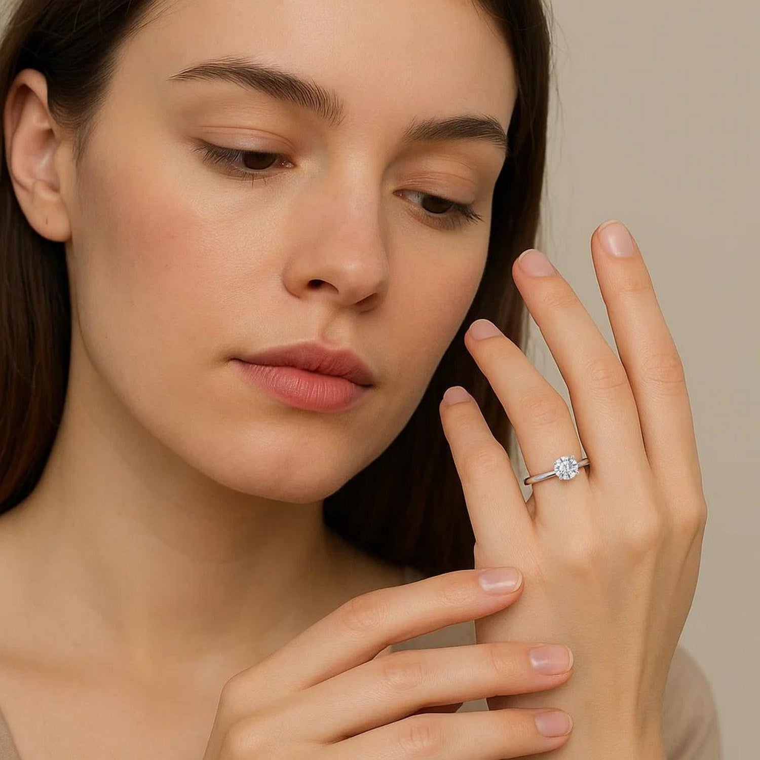 A woman wears a sterling silver solitaire ring with a round lab-grown diamond.
