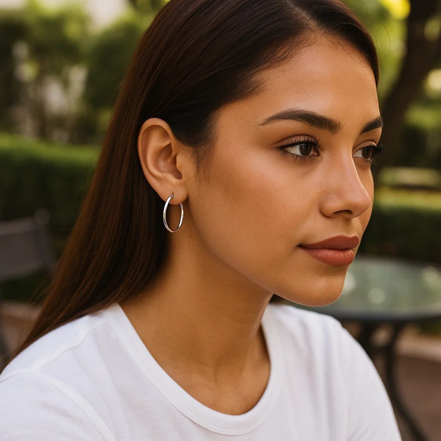 Sterling silver hoop earrings with rhodium plating on a woman.