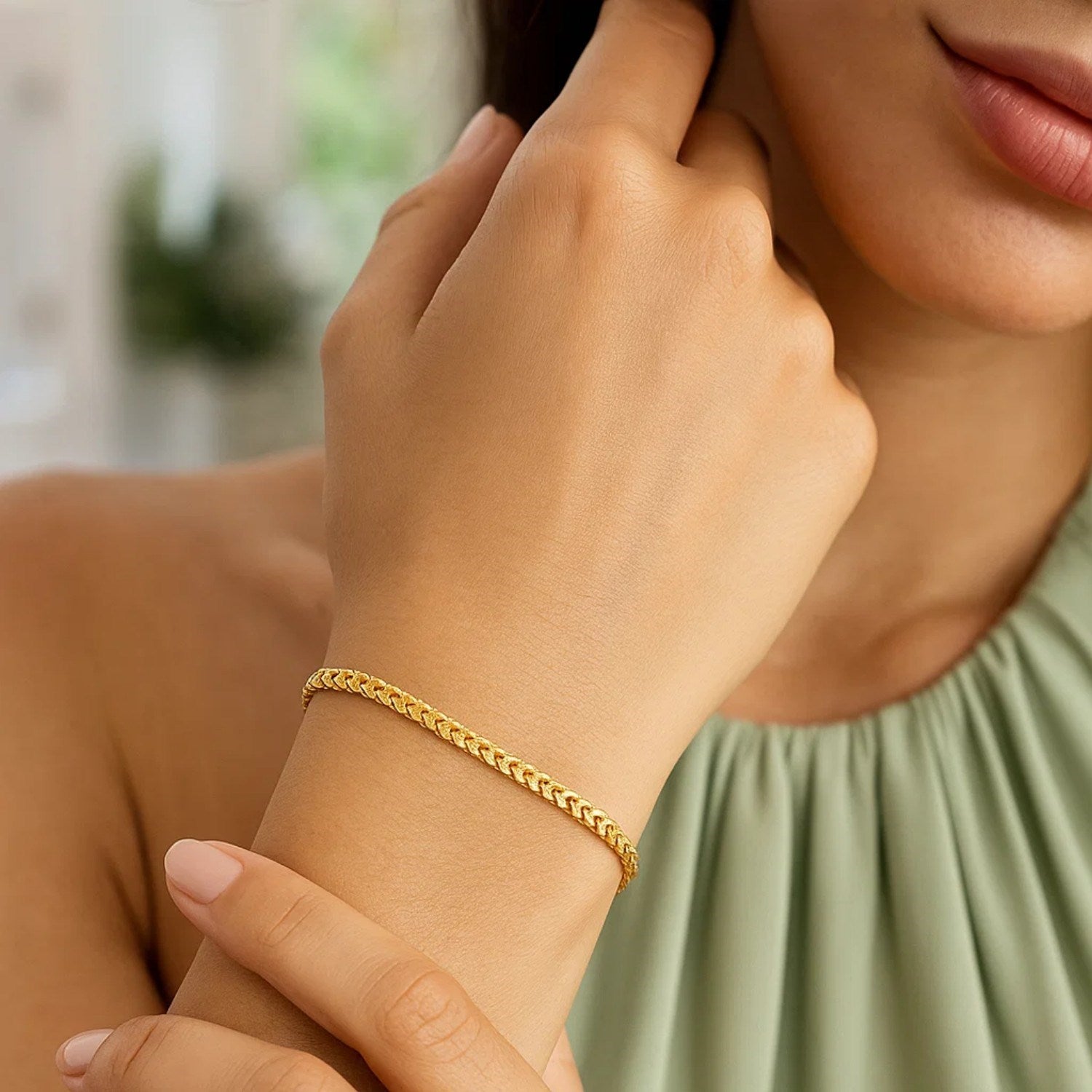 14k yellow gold solid diamond cut round franco bracelet on a woman's wrist.