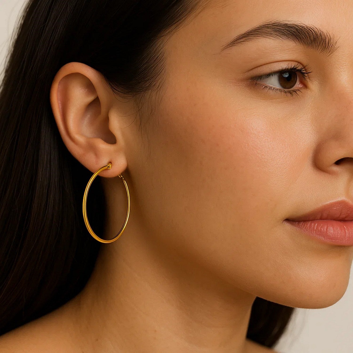 10k yellow gold polished hoop earrings on a model.