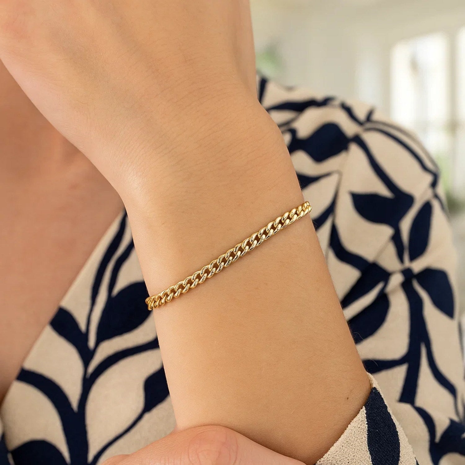 14k yellow gold classic Miami Cuban solid bracelet on a person's wrist.