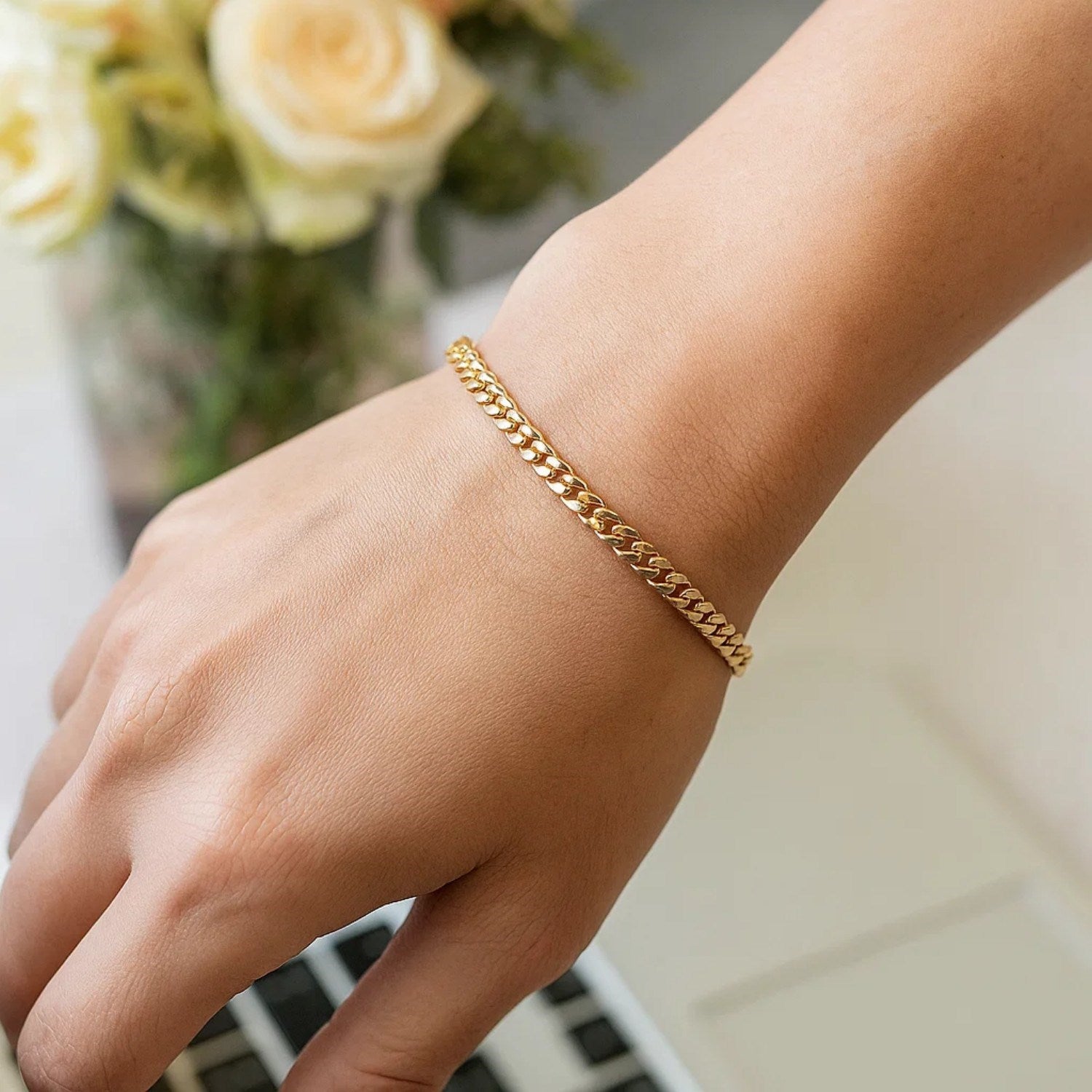 14k yellow gold classic Miami Cuban solid bracelet on a person's wrist.