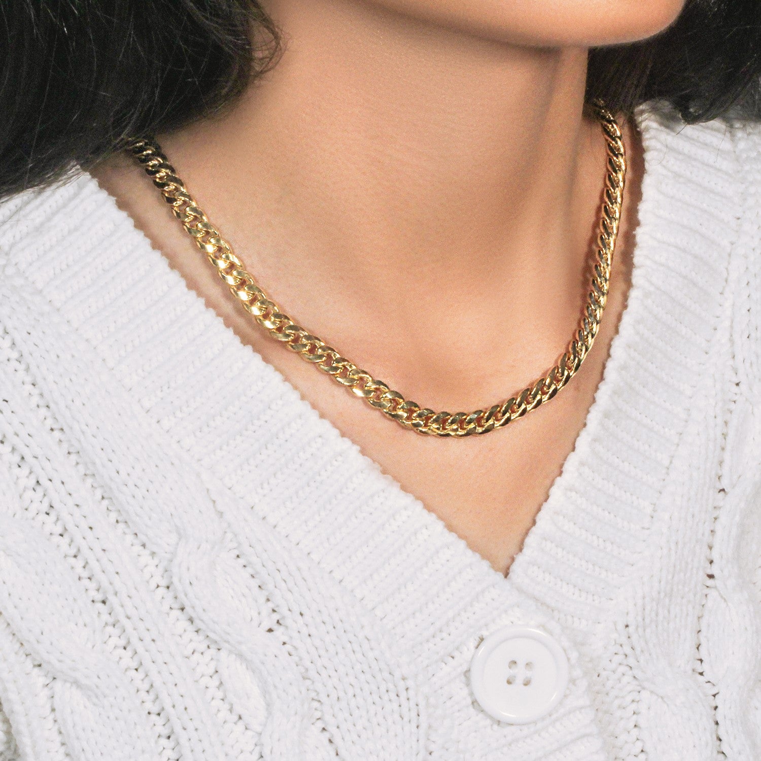 14k yellow gold Miami Cuban semi-solid chain on a person wearing a white sweater.