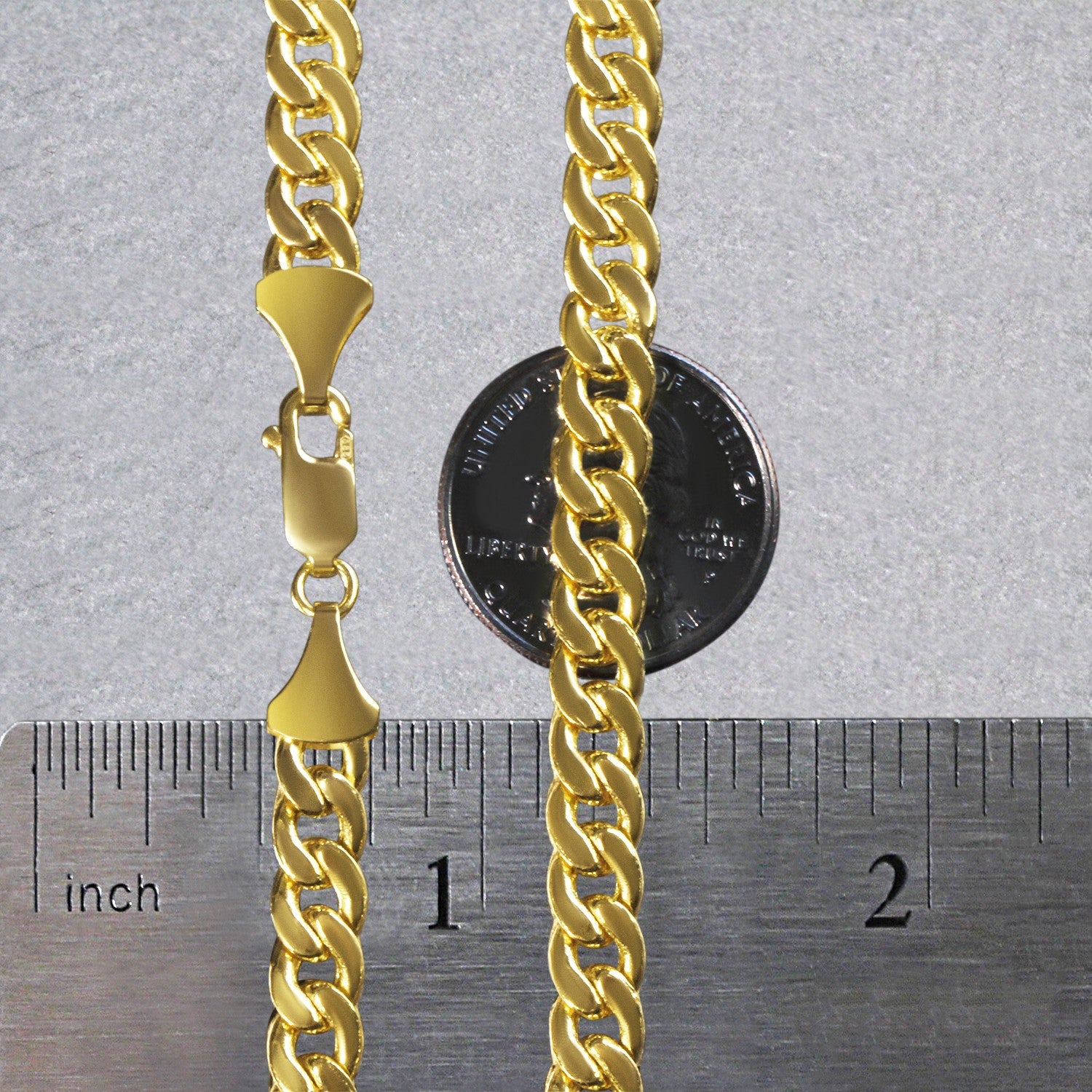 A 14k yellow gold Miami Cuban semi-solid chain with a lobster clasp, shown with a ruler and coin for scale.