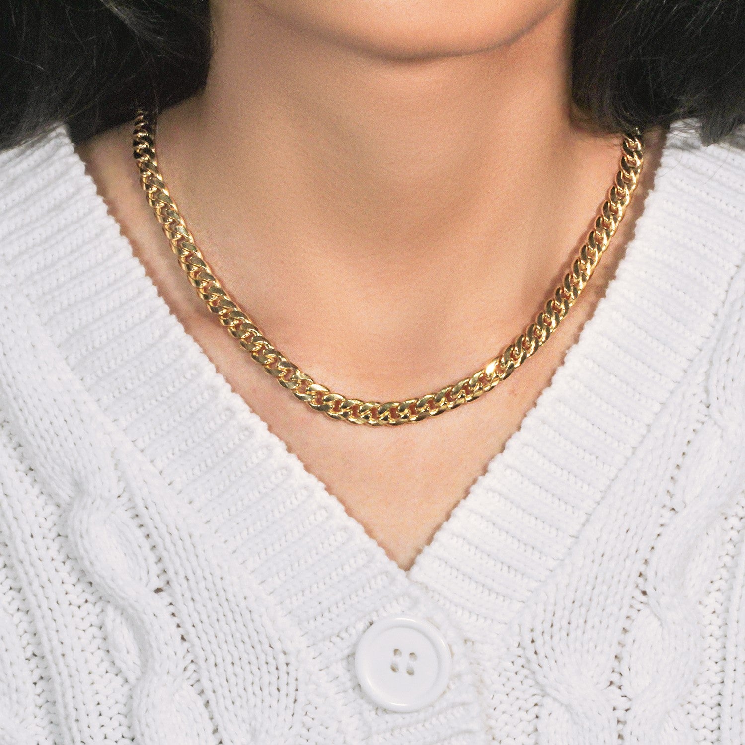14k yellow gold Miami Cuban semi-solid chain on a person wearing a white sweater.