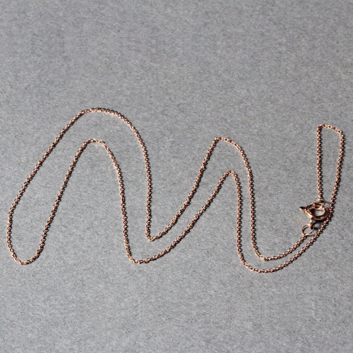A delicate 14k rose gold diamond-cut cable link chain with a spring ring clasp.