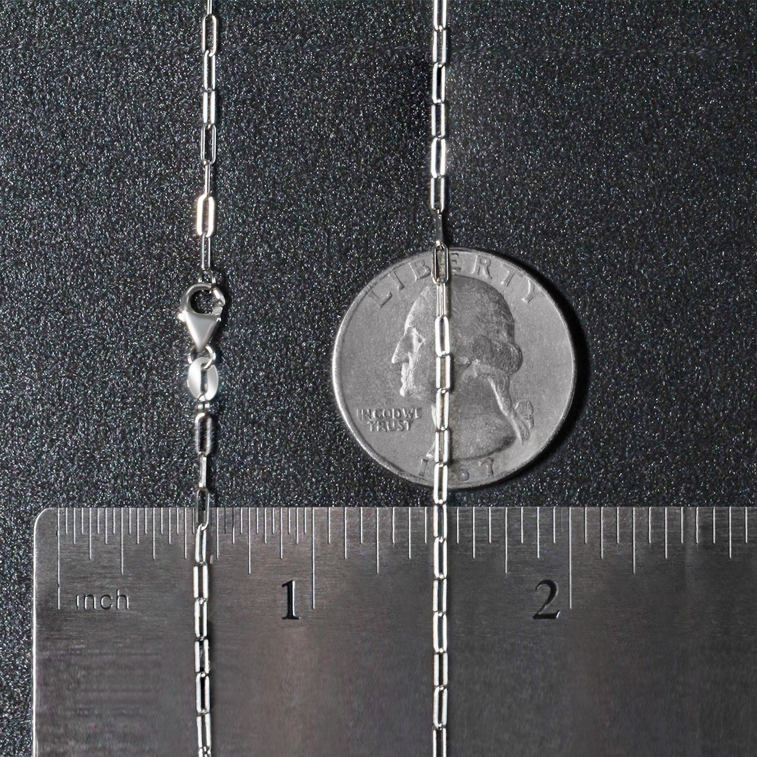 A 14K white gold paperclip chain with a lobster clasp is shown next to a ruler and quarter.