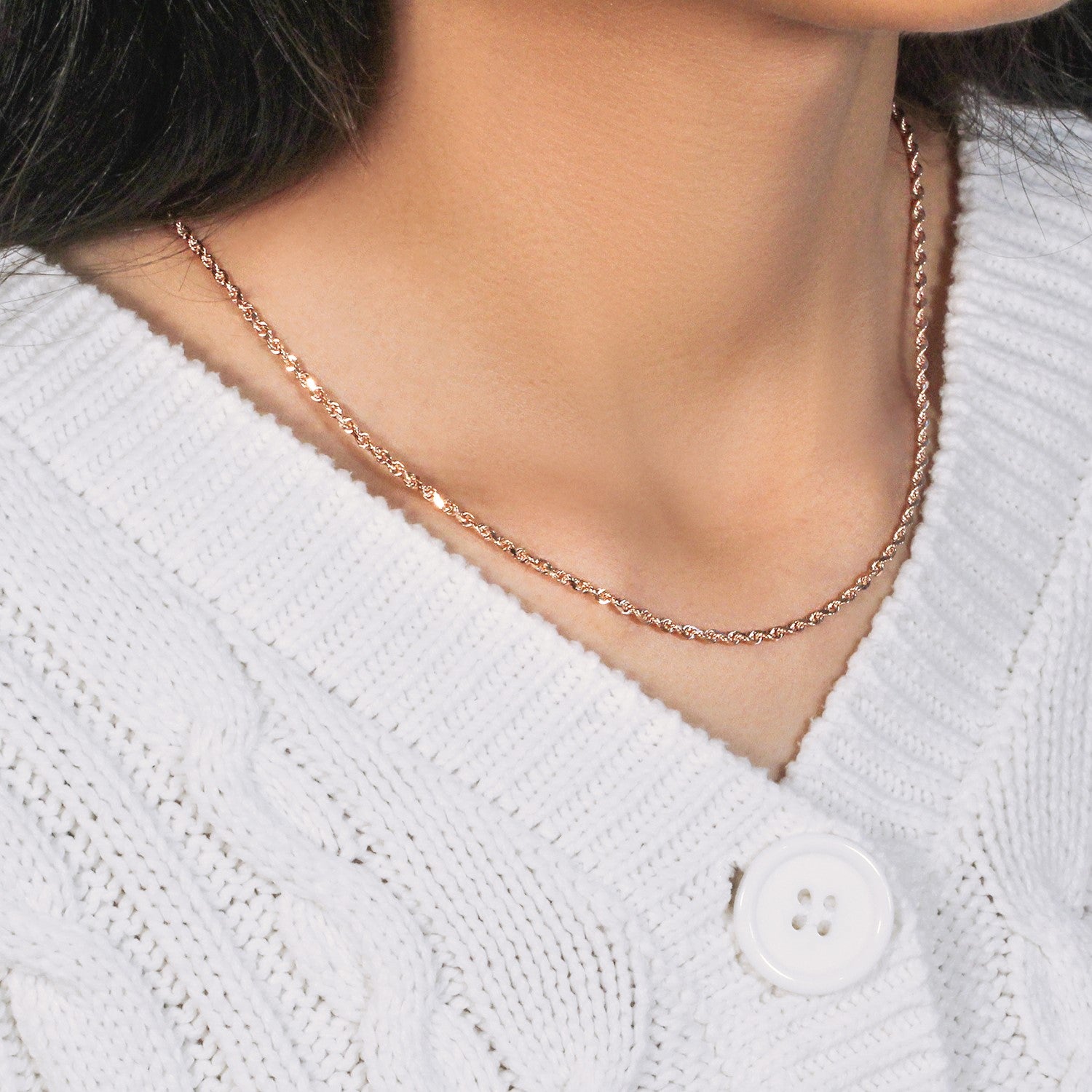 14k rose gold solid diamond cut rope chain on a person wearing a white sweater.