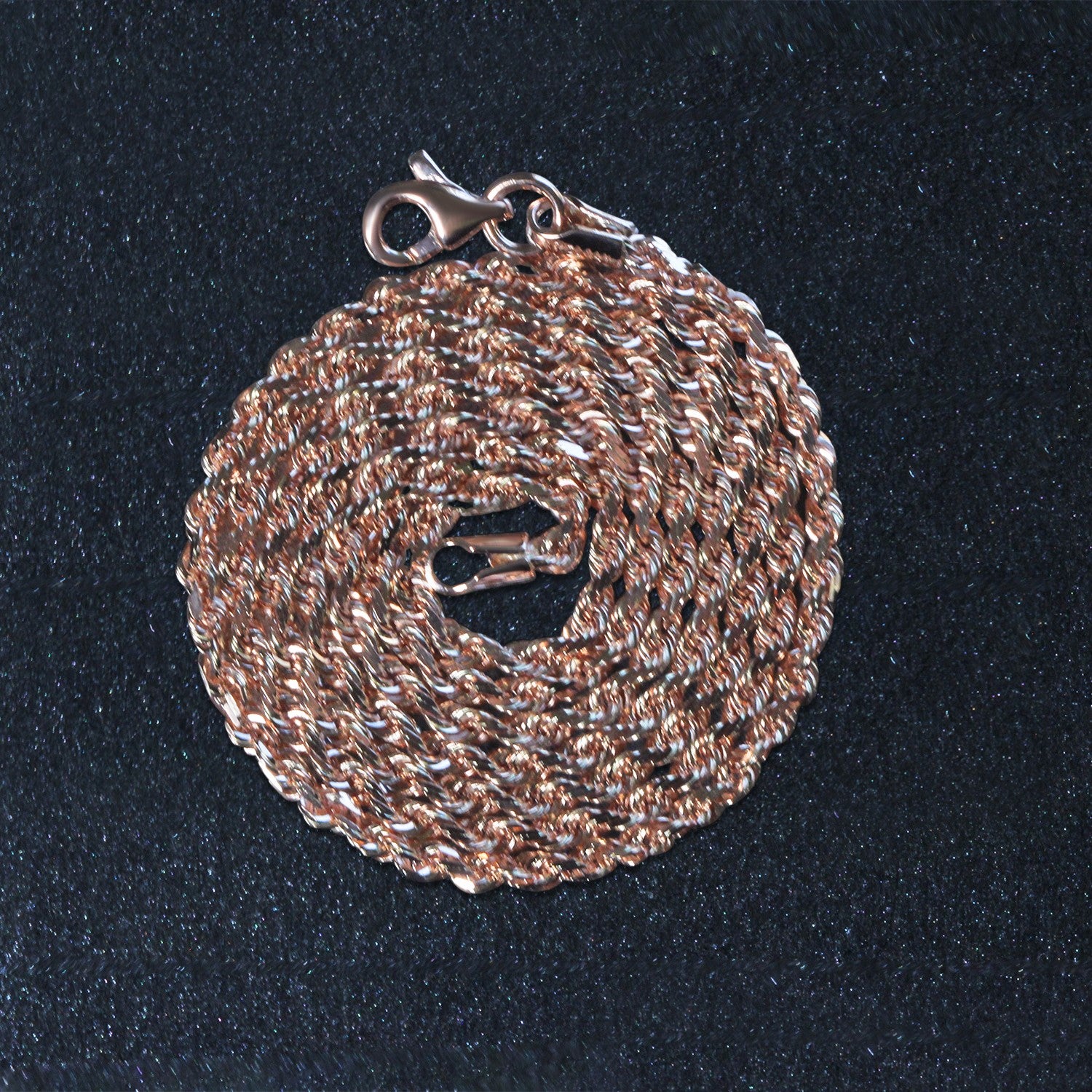 14k rose gold solid diamond cut rope chain with a lobster clasp, coiled on a dark surface.