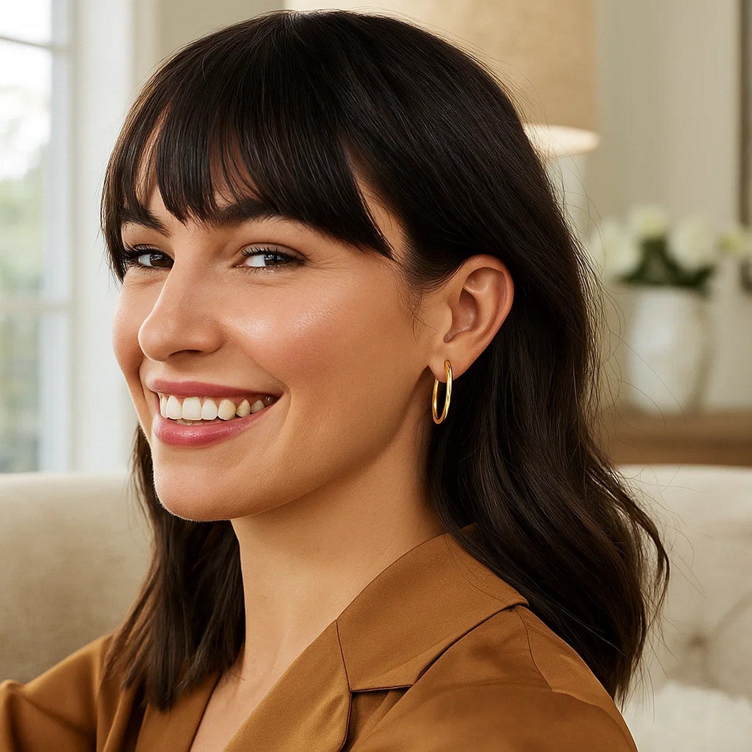 14k yellow gold endless oval hoop earrings on a smiling woman.