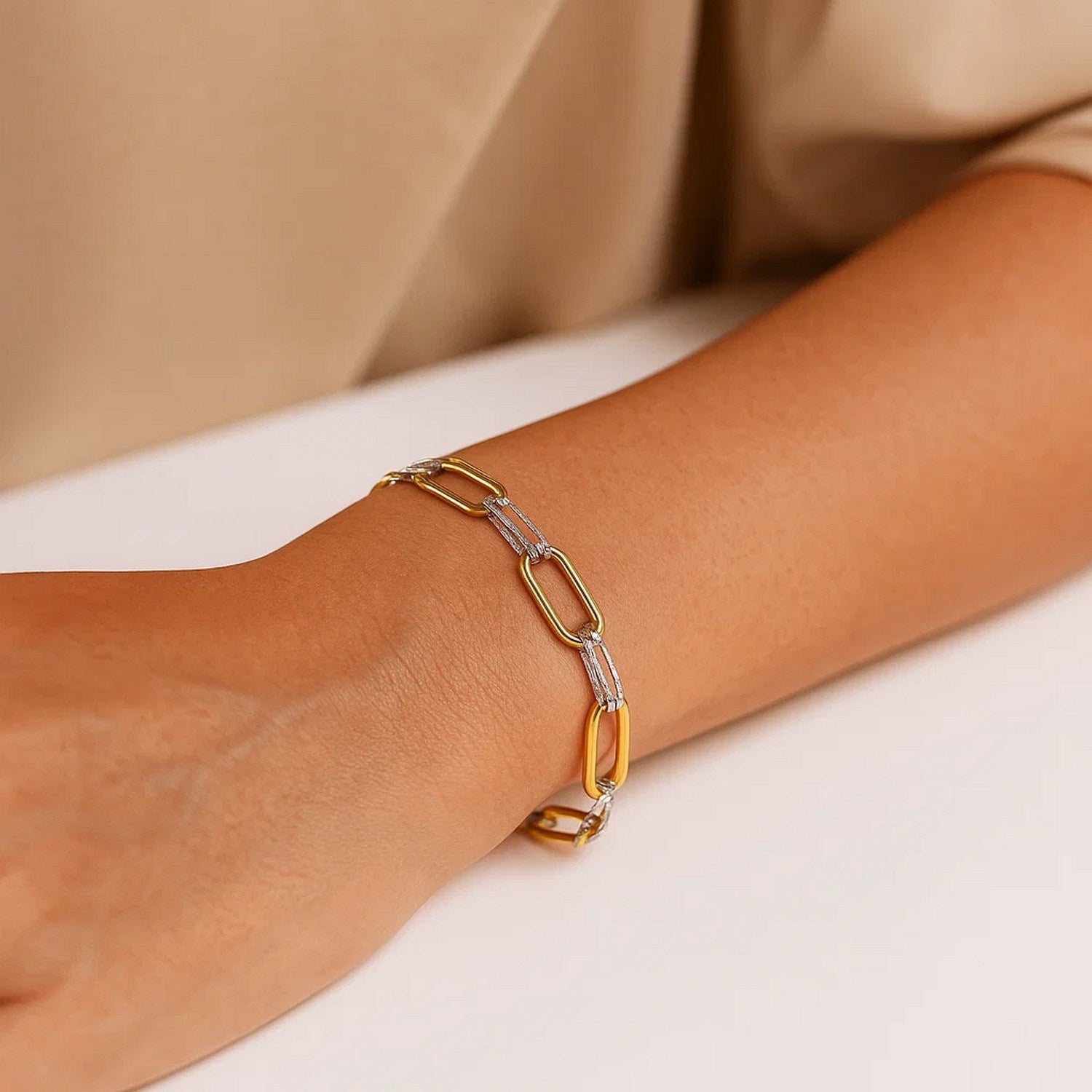 14K two-tone gold paperclip bracelet on a person's wrist.