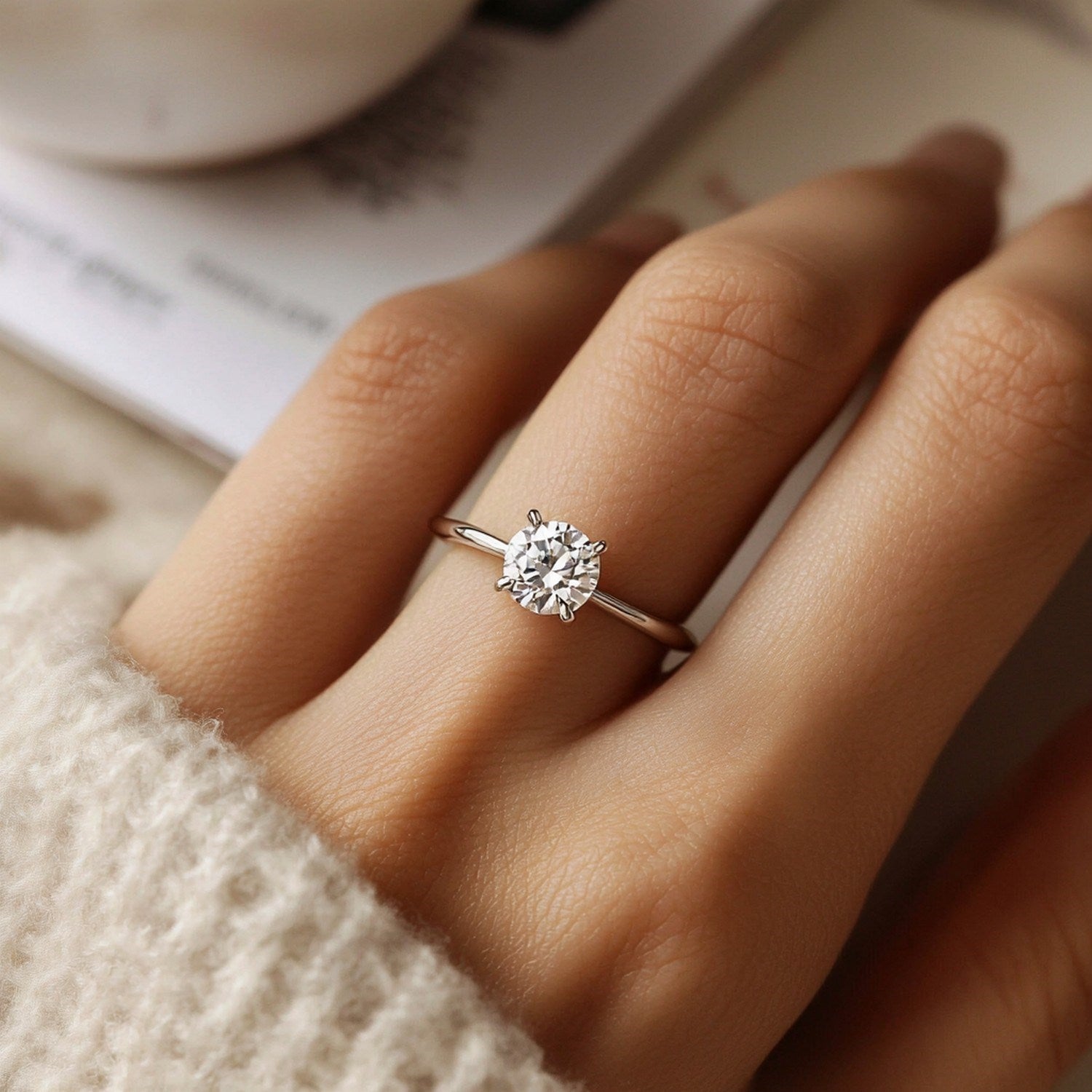 A hand wears a 2 carat round lab grown diamond solitaire ring in 10K white gold.