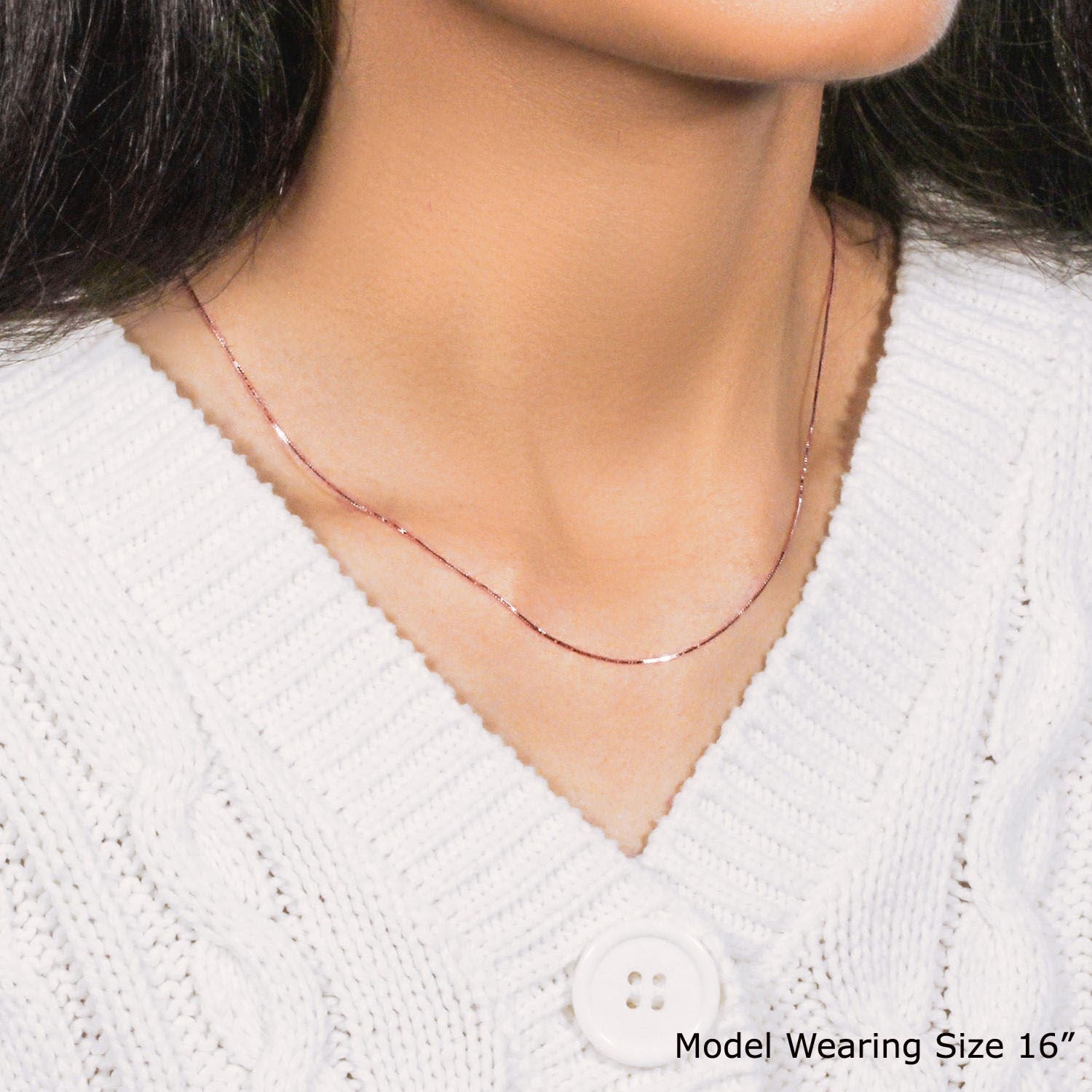A 14k rose gold classic box chain (0.60 mm) on a model wearing a white sweater.