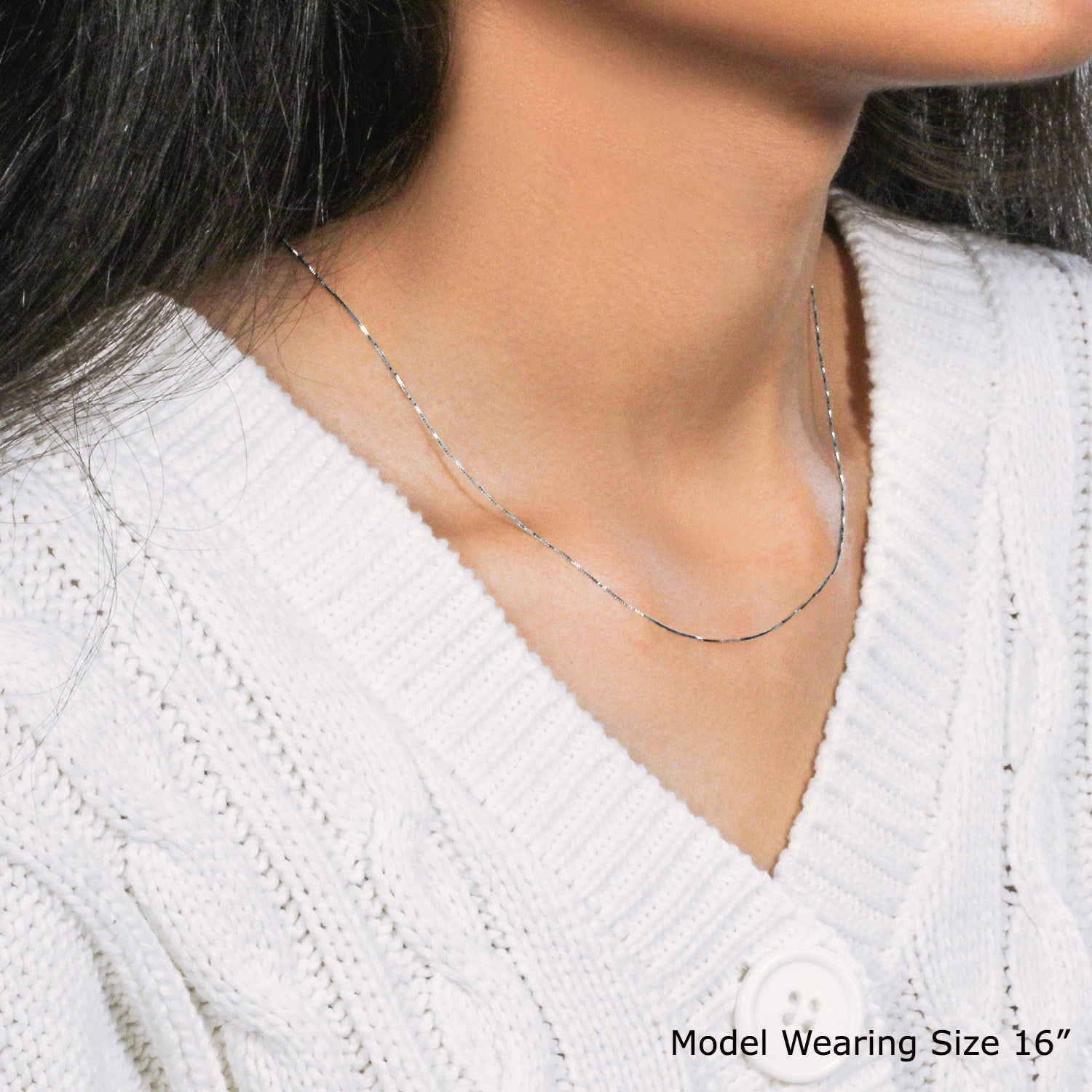 A 14k white gold classic box chain, 0.45 mm wide, worn by a model.