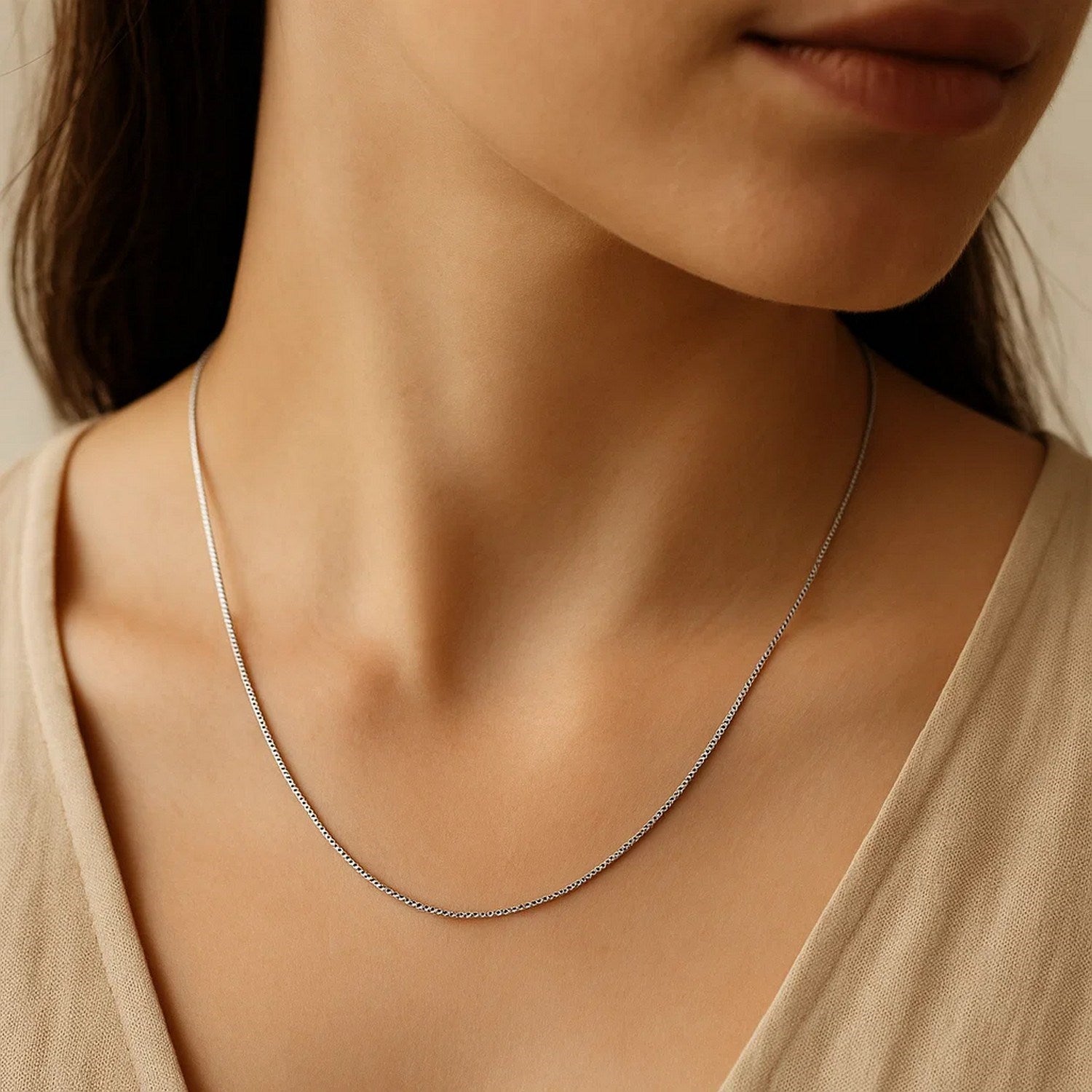 A woman wears a delicate 14k white gold classic box chain.