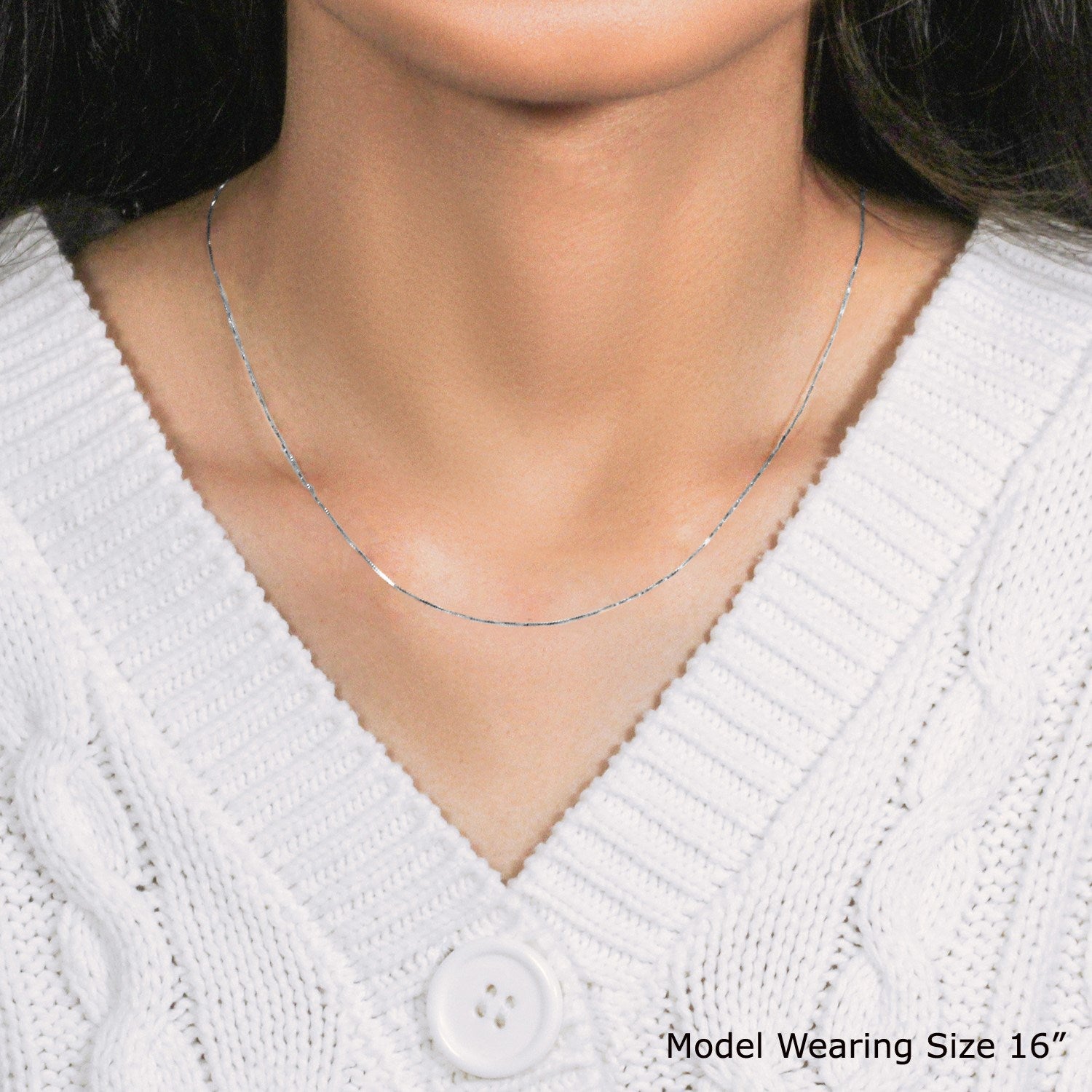 A 14k white gold classic box chain, 0.45 mm wide, worn by a model.