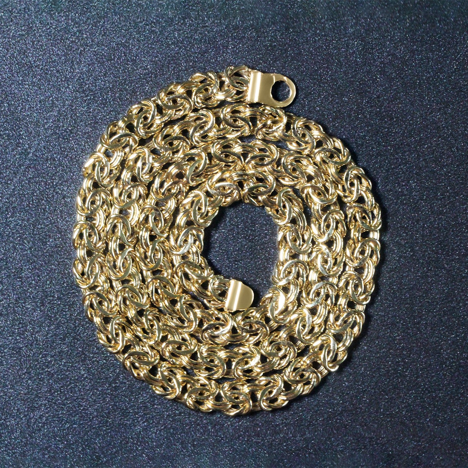 14k yellow gold Byzantine chain necklace with a lobster clasp, coiled on a dark surface.