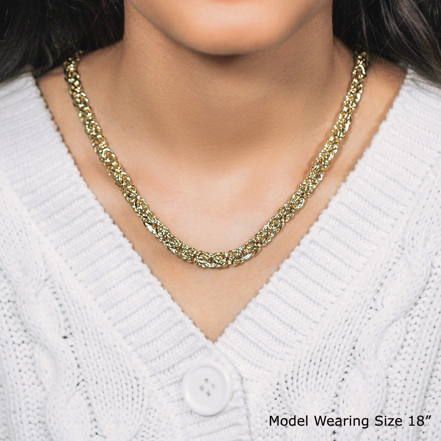 14k yellow gold Byzantine chain necklace on a model wearing a white sweater.