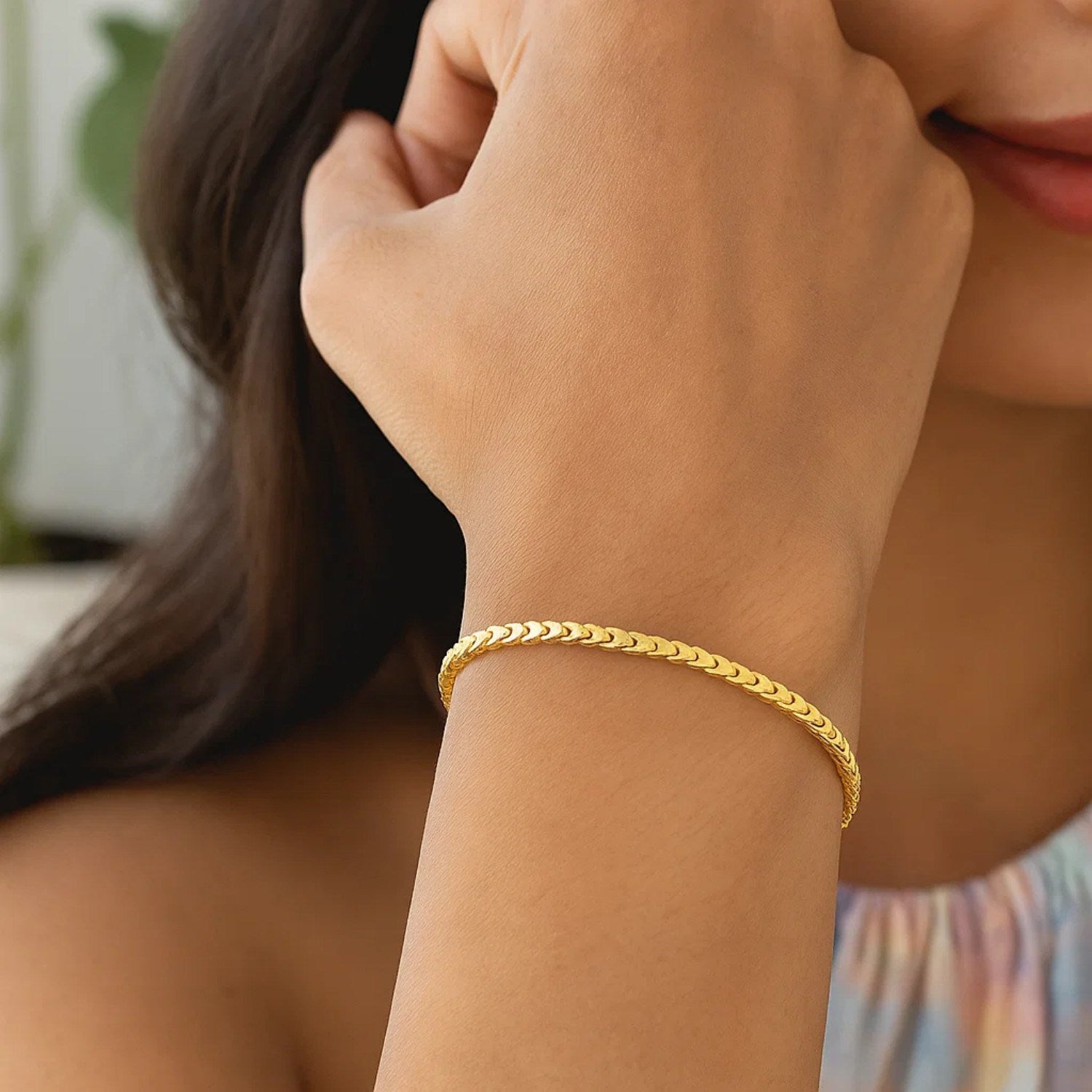 A 14k yellow gold solid diamond cut round franco bracelet on a person's wrist.