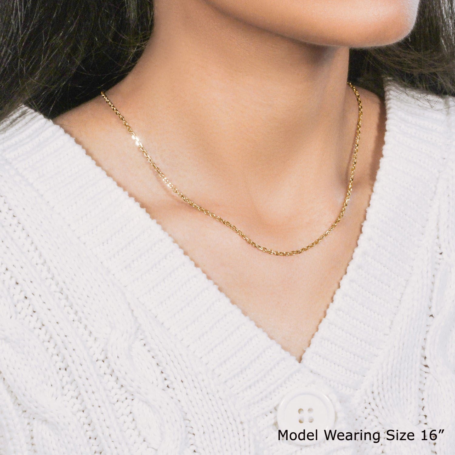 18k yellow gold diamond cut cable link chain on a model wearing a white sweater.