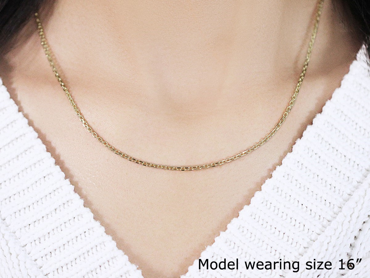 An 18k yellow gold diamond cut cable link chain, 1.90 mm wide, worn by a model.