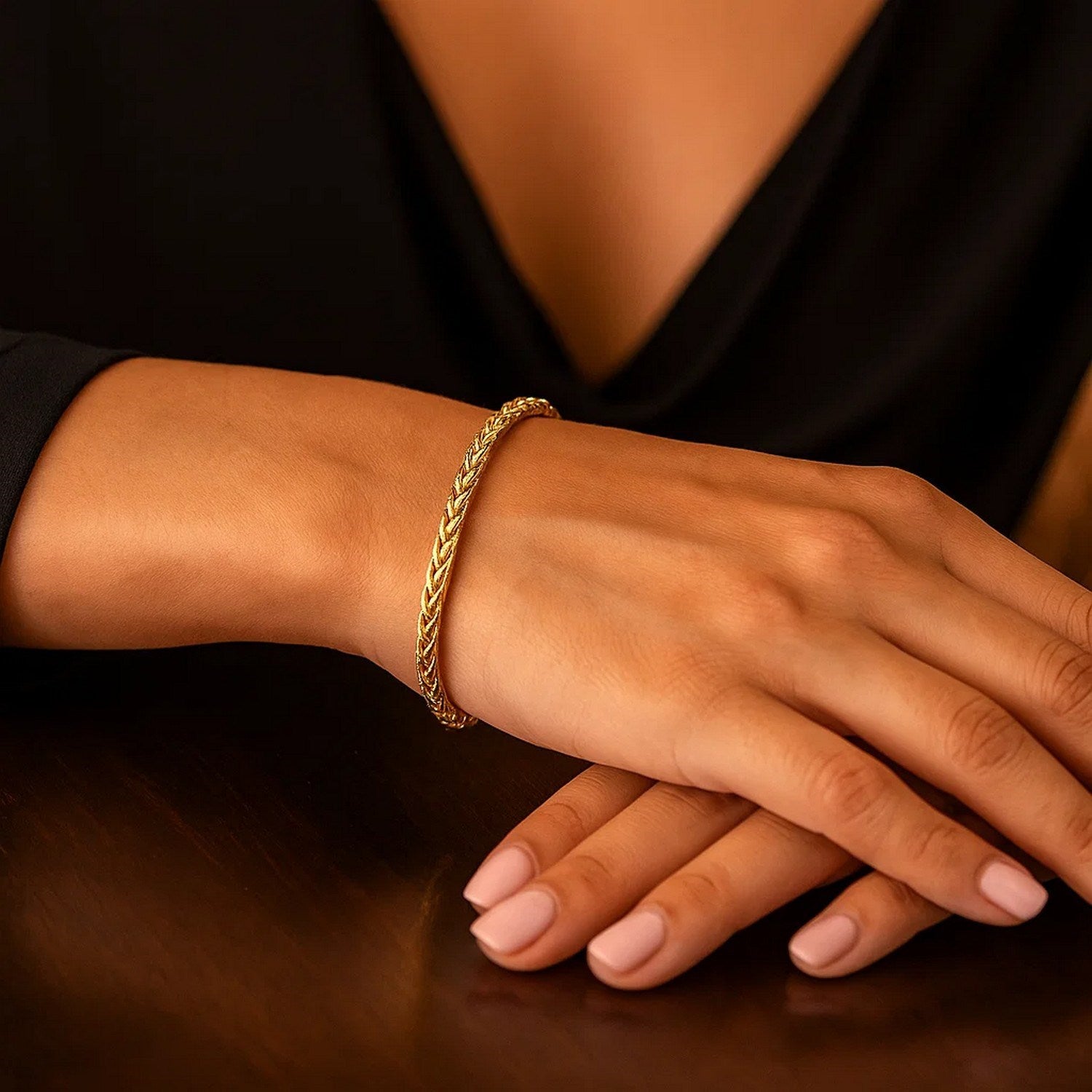 A 14k yellow gold light weight wheat bracelet on a person's wrist.