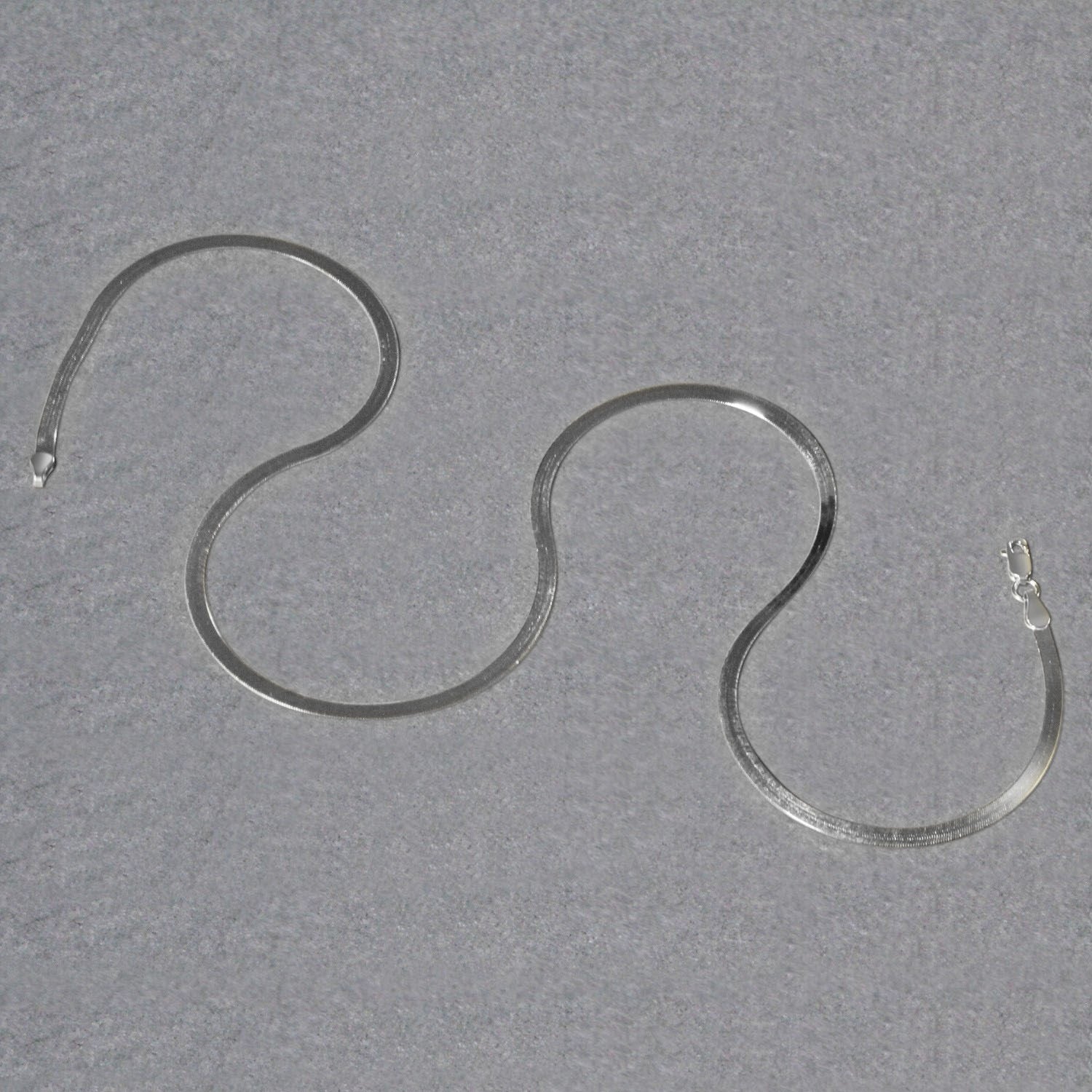 A 14k white gold super flex herringbone chain with a lobster clasp.