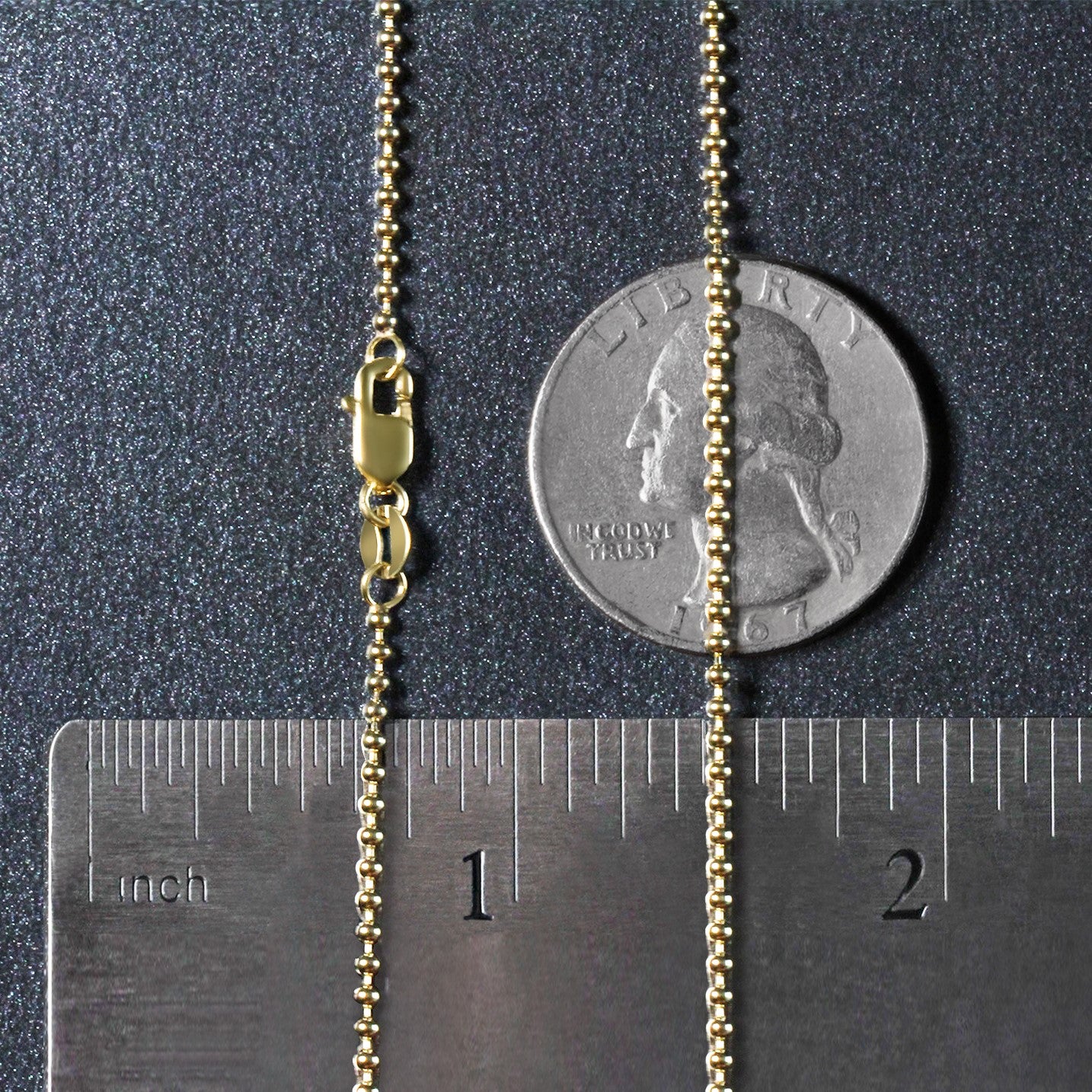 14k yellow gold 1.5mm bead chain with a lobster clasp, shown with a ruler and coin.