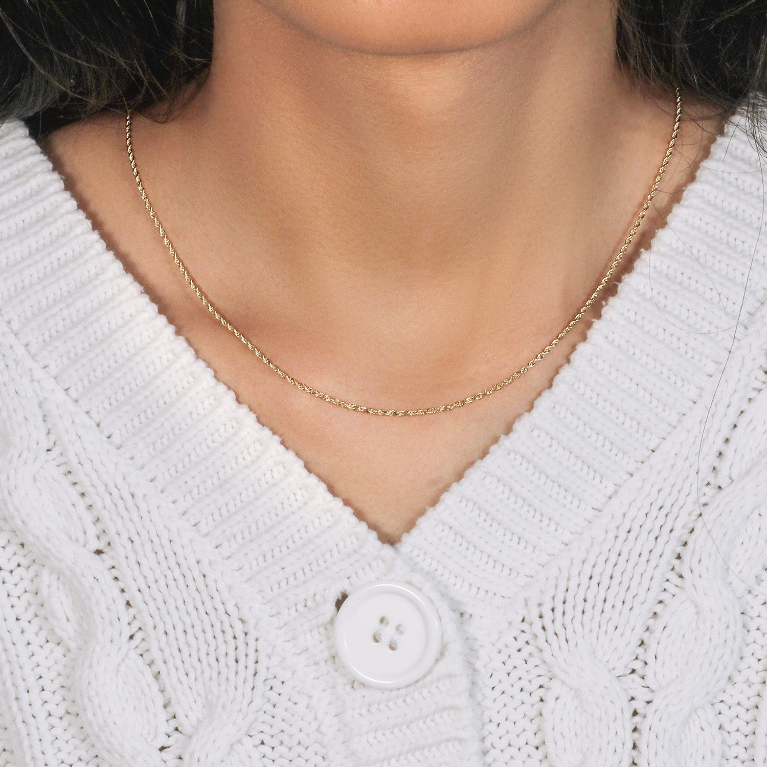 A 10k yellow gold solid diamond cut rope chain is worn around a person's neck.