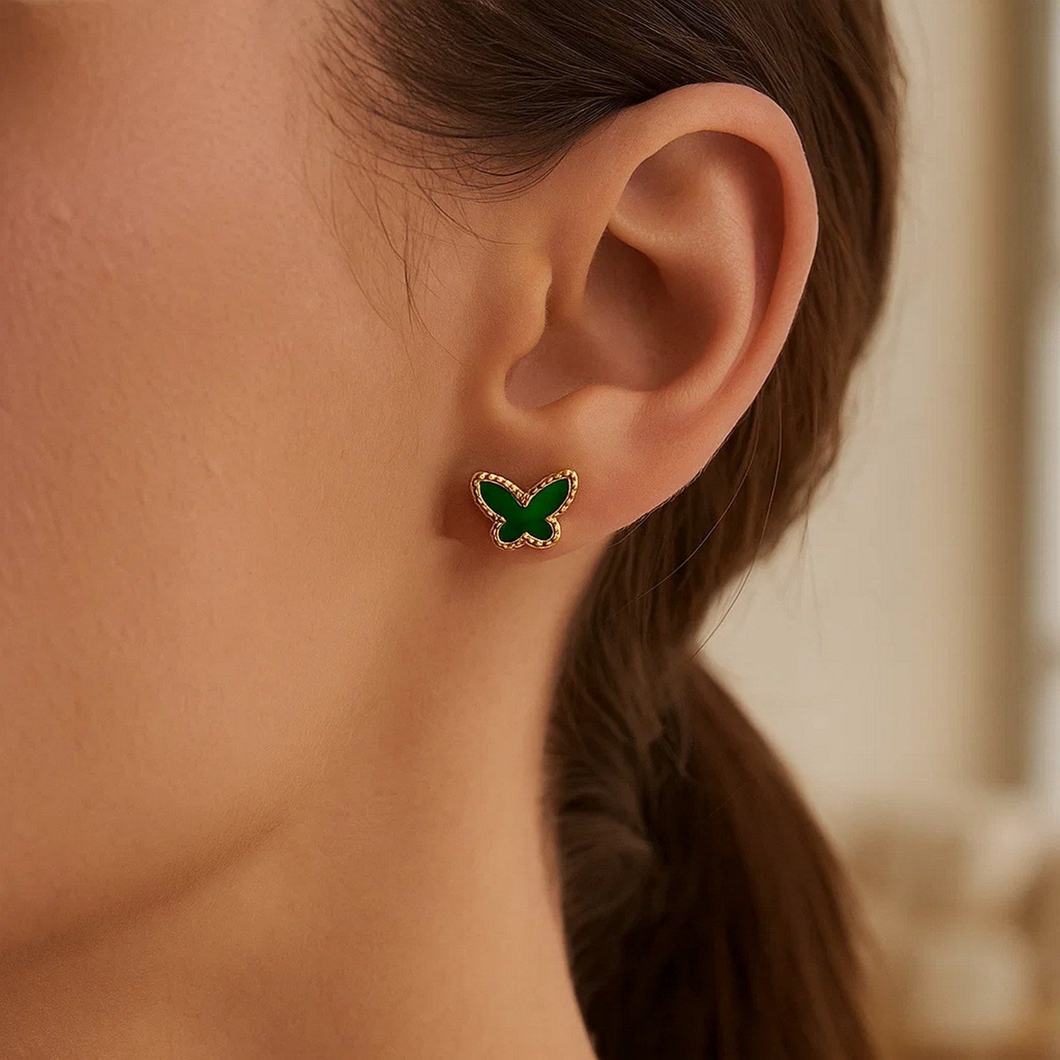 14K yellow gold butterfly stud earring with a green malachite inlay on a person's ear.