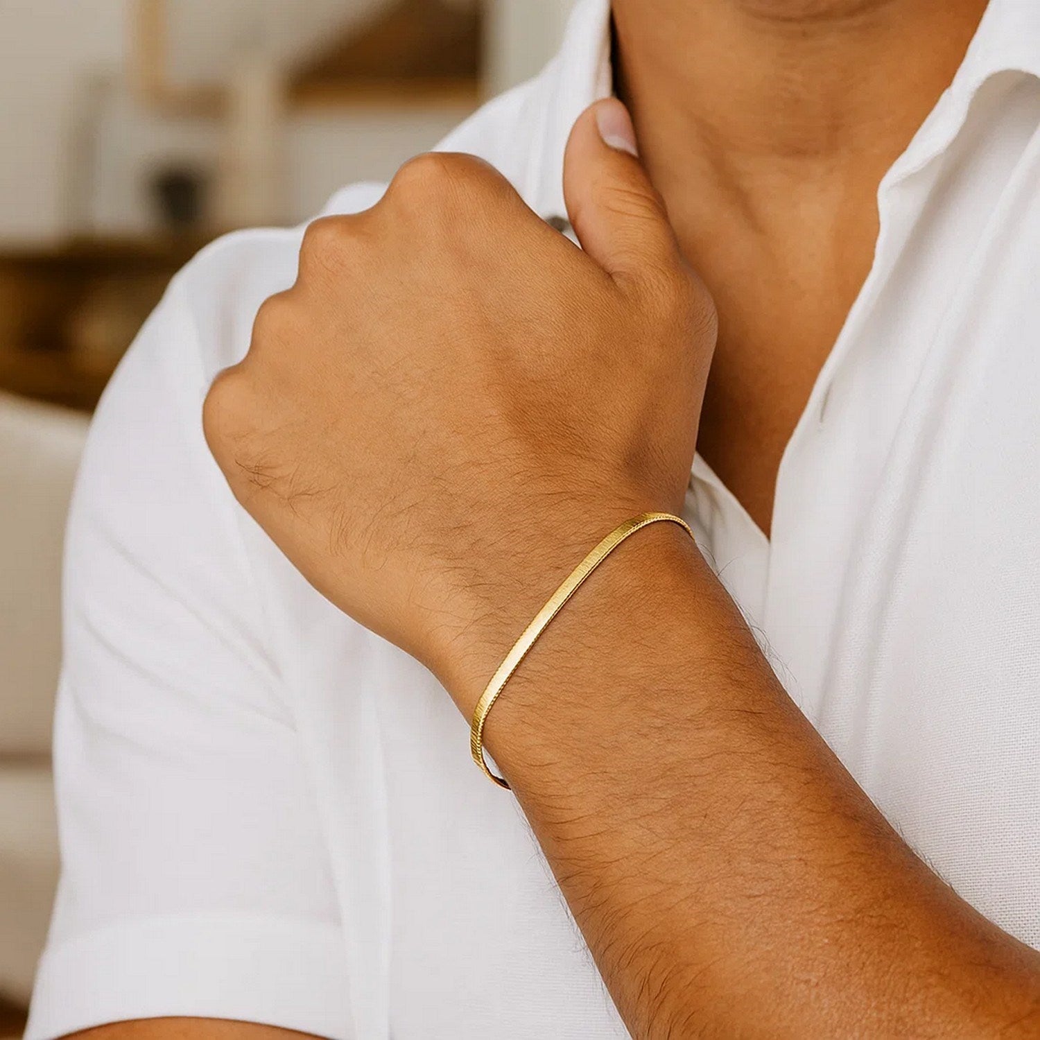 14k yellow gold super flex herringbone bracelet on a person's arm.