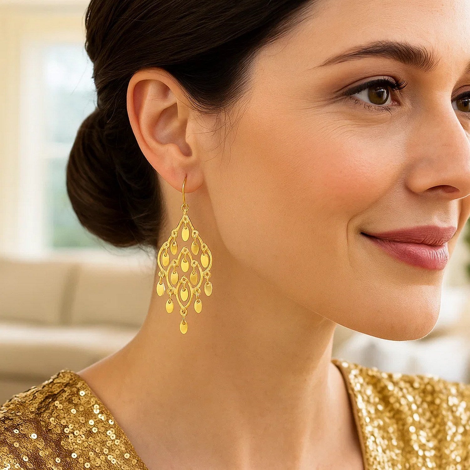 14K yellow gold polished chandelier earrings with open oval shapes on a woman.